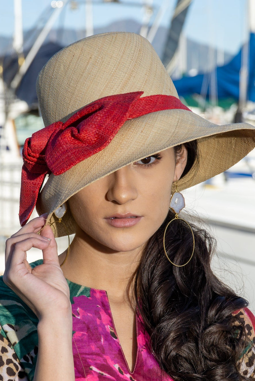 Model wearing Cara Big Bow Straw Hat Handmade loomed raffia straw hat solid natural bucket hat with large red bow - Shebobo