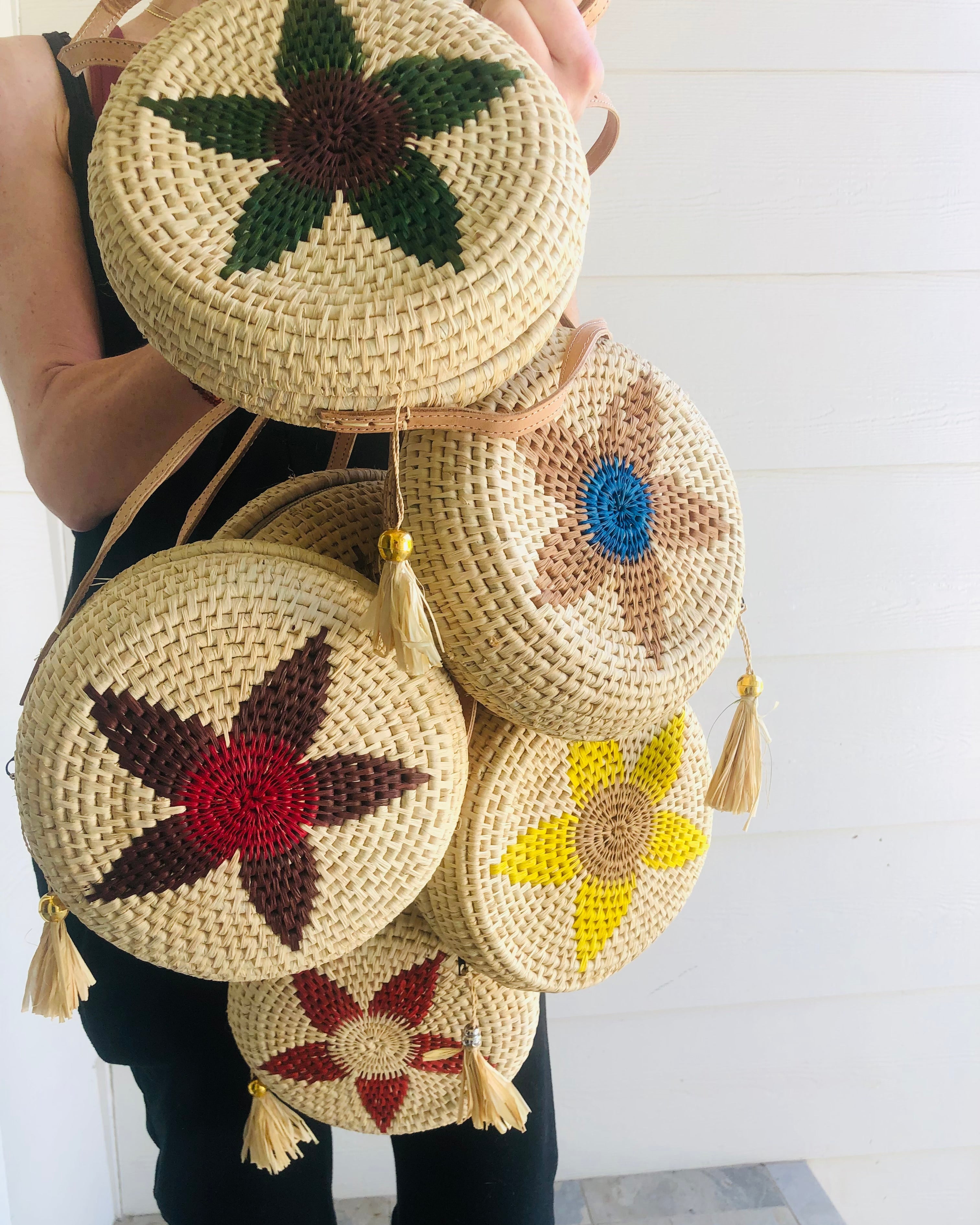 Model wearing multiple Carmel Crochet Round Flower Crossbody bag with Tassel Assorted Flower colors with adjustable leather strap and tassel zipper pull purse - sold assorted - Shebobo
