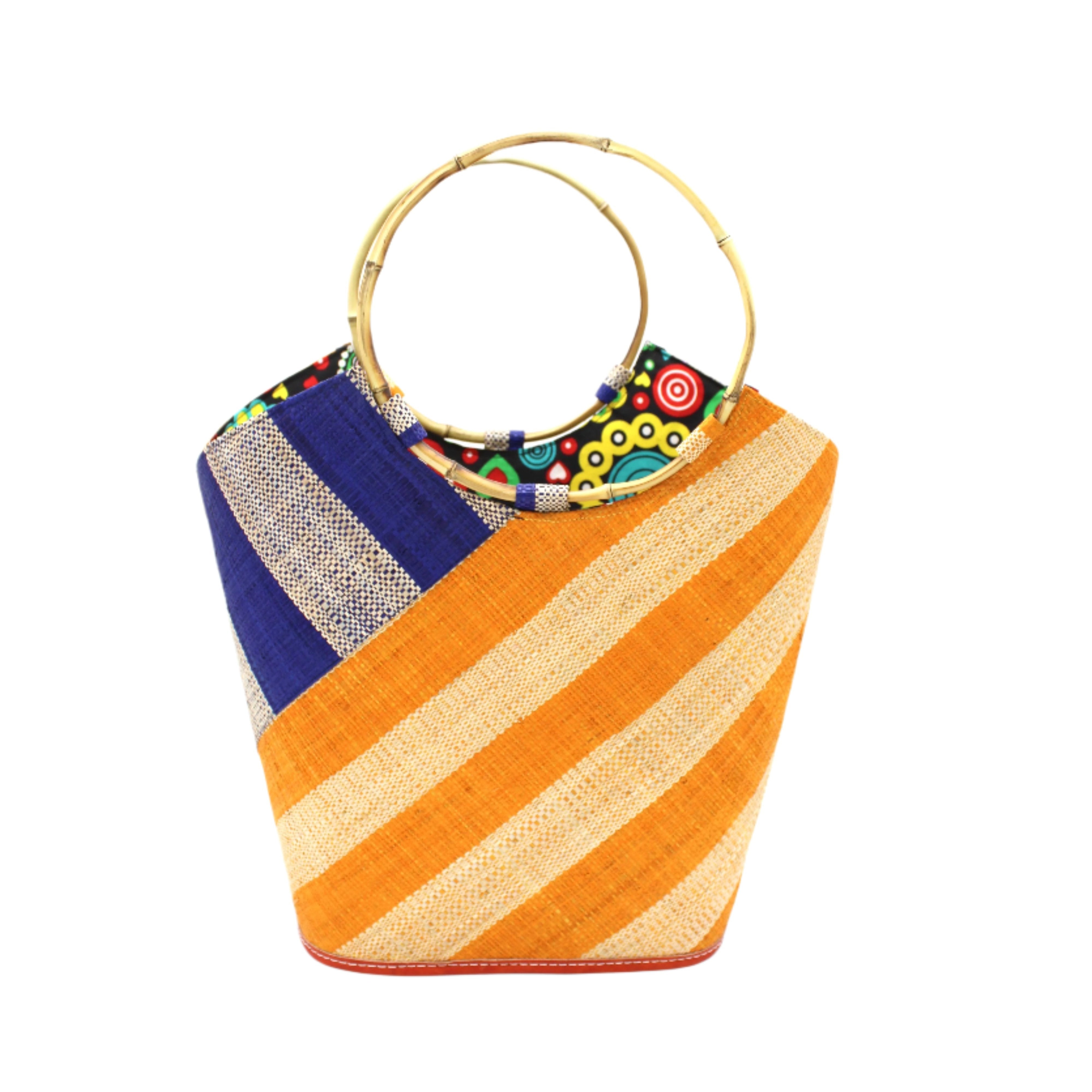 Carmen Double Wide Stripe Saffron & Dusk Straw Bucket Bag w/ Bamboo Handle handmade loomed raffia palm fiber in even width wide stripe pattern of Saffron yellow/orange and natural straw color oriented on the diagonal of three quarters of the bag with matching stripe pattern of dusk navy/dark/blue and natural diagonally on the top left corner quarter shoulder bag handbag - Shebobo
