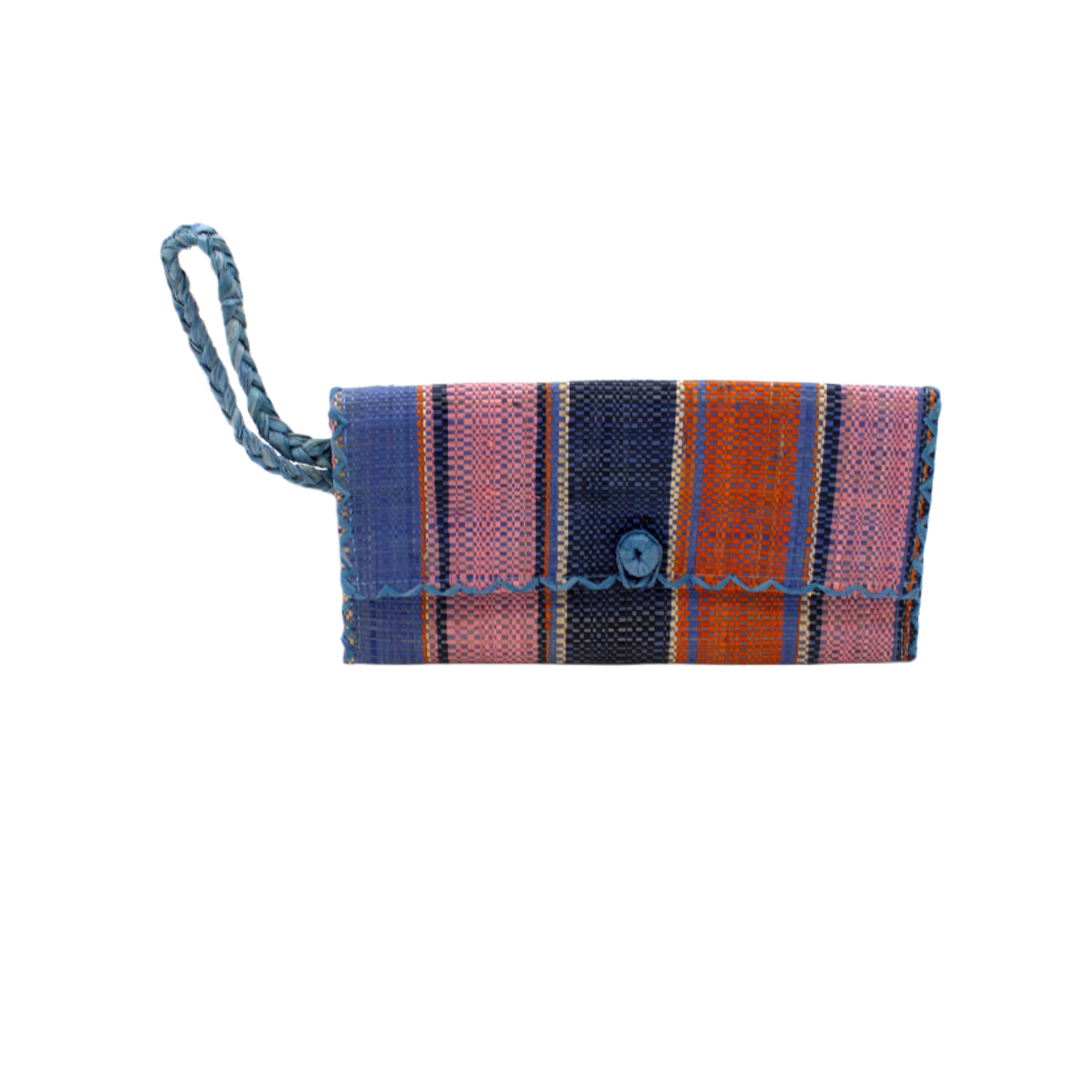 ChiChi Retro Swirl Multicolor Straw Clutch Bag handmade loomed raffia palm fiber wristlet in multi-width bands of denim retro/light blue, dusk dark/navy/blue, pink, coral orange/red, and natural straw color that create a vertical stripe pattern with denim blue color cross stitch edging, button & loop closure, and braided wrist strap - Shebobo
