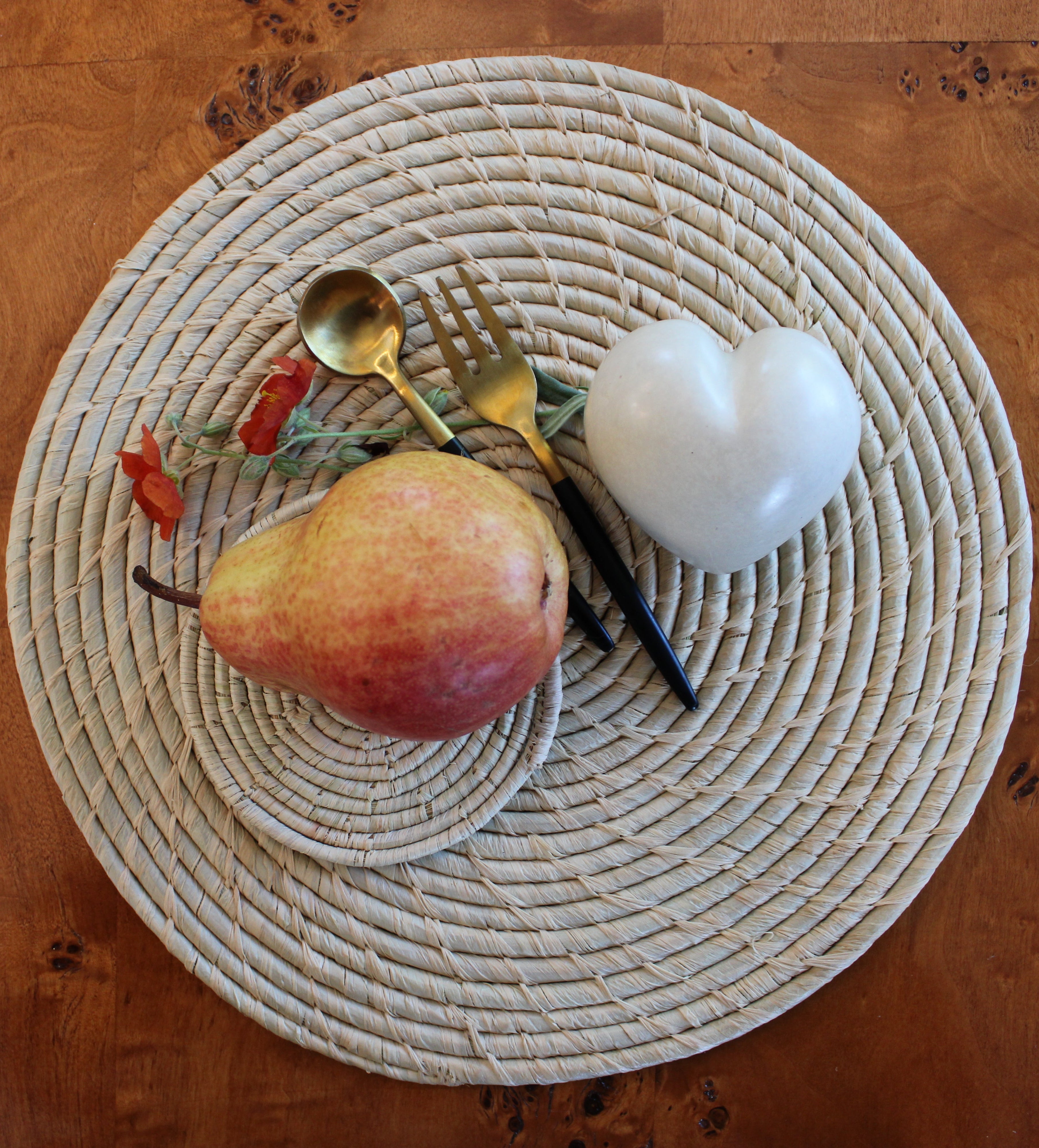 Lifestyle view Dabu Round Two Tone Swirl Raffia Straw Coasters & Placemats Set of 6 handmade natural raffia palm fiber in a crochet loop disc technique creating concentric circular stripe pattern of texture in a solid hue of natural straw color with matching knotted spiral swirl weave sets of six placemats or coasters - Shebobo