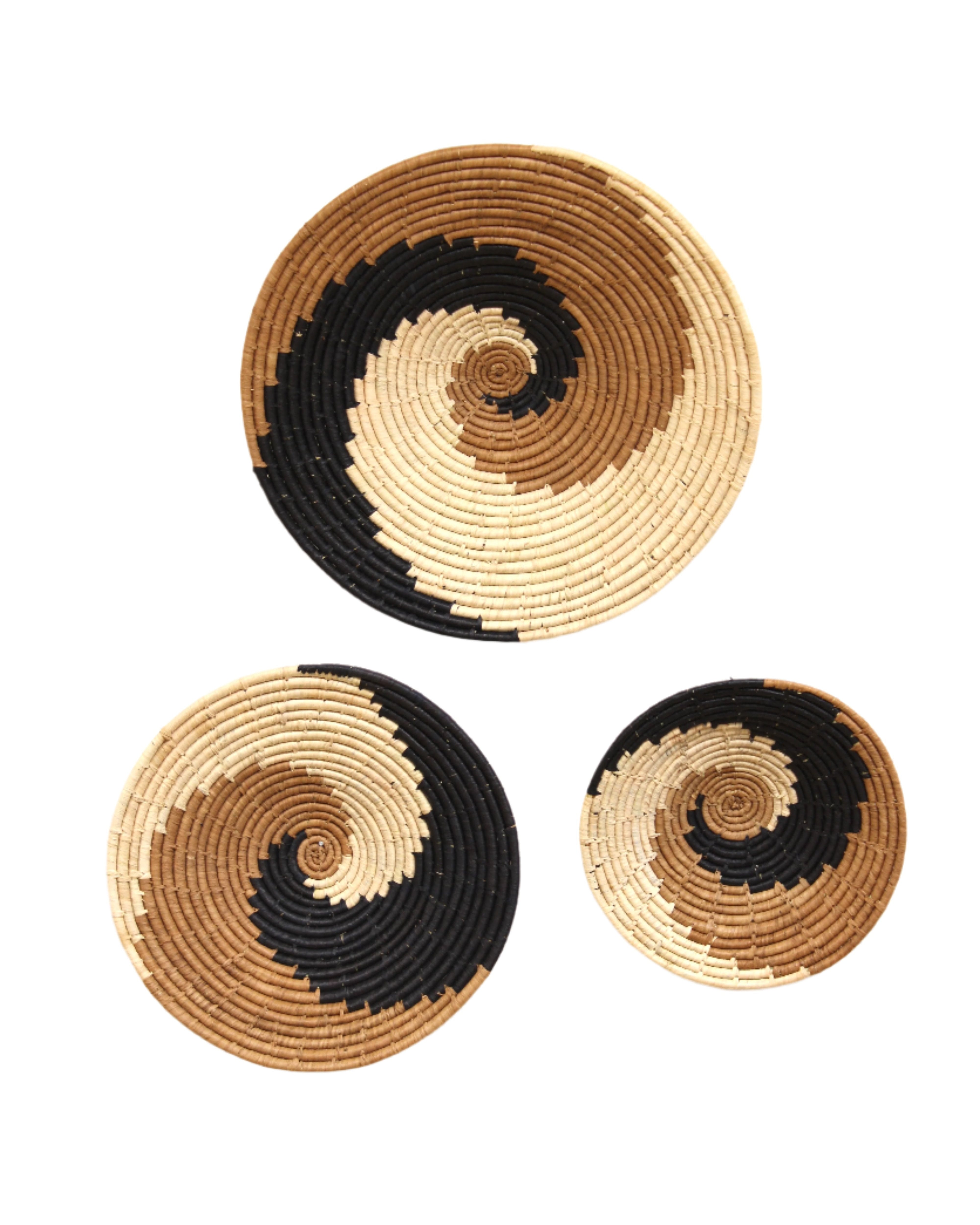 Dakarai Raffia Straw Wall Decor Display Basket Trays: Set of 3 handmade woven raffia palm fiber in a crochet loop technique creating a concentric swirl pattern of bands of natural straw color, cinnamon/tobacco/brown, and black in a three tone spiral from the center to the outer edge set of three sized flat bowl trays - Shebobo