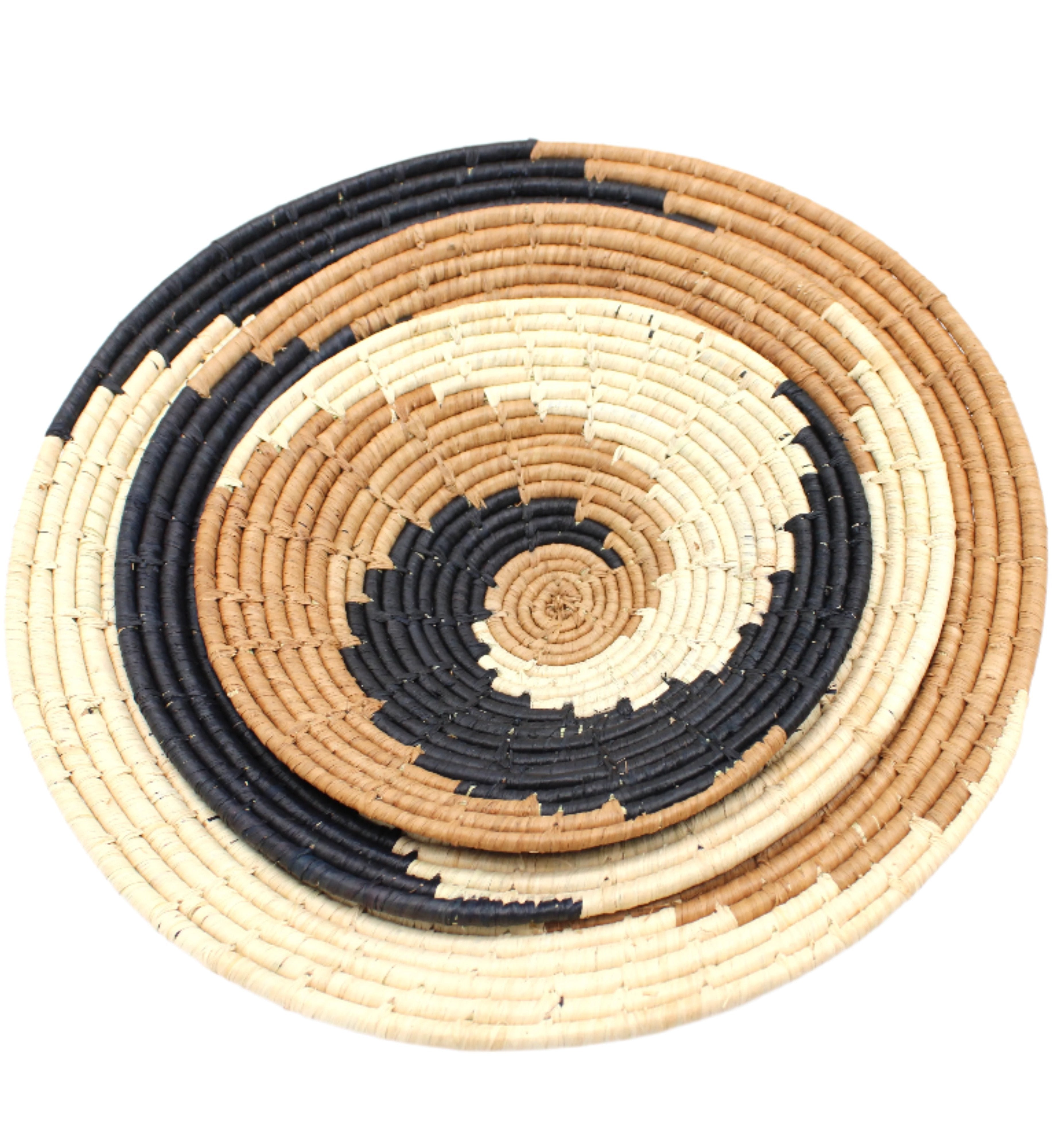 Detail view Dakarai Raffia Straw Wall Decor Display Basket Trays: Set of 3 handmade woven raffia palm fiber in a crochet loop technique creating a concentric swirl pattern of bands of natural straw color, cinnamon/tobacco/brown, and black in a three tone spiral from the center to the outer edge set of three sized flat bowl trays - Shebobo
