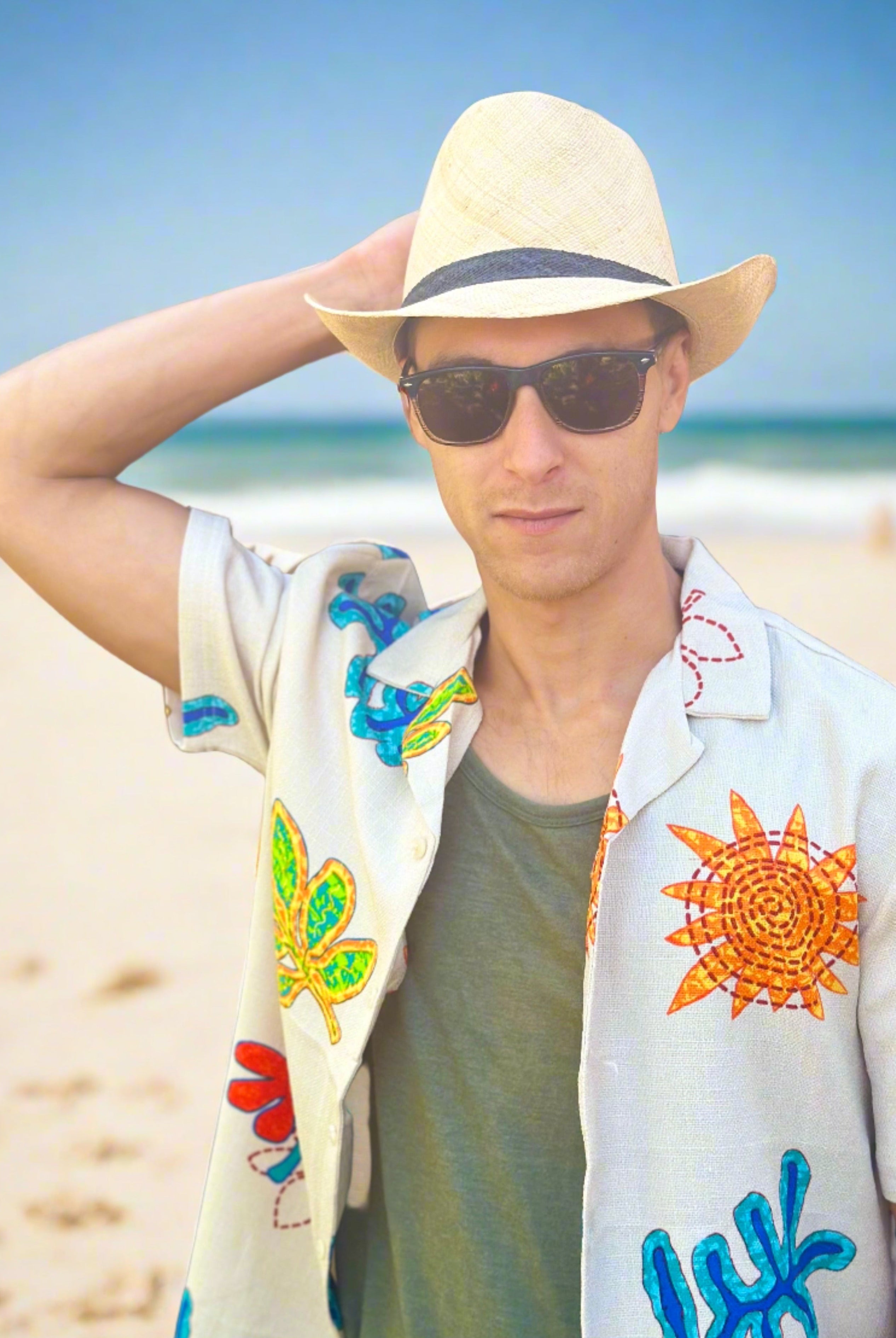 Model wearing Fedra Natural with Black Hat Band - Unisex Fedora Straw Hat handmade loomed natural raffia palm fiber in a solid hue of natural straw color with an attached black hat band - Shebobo