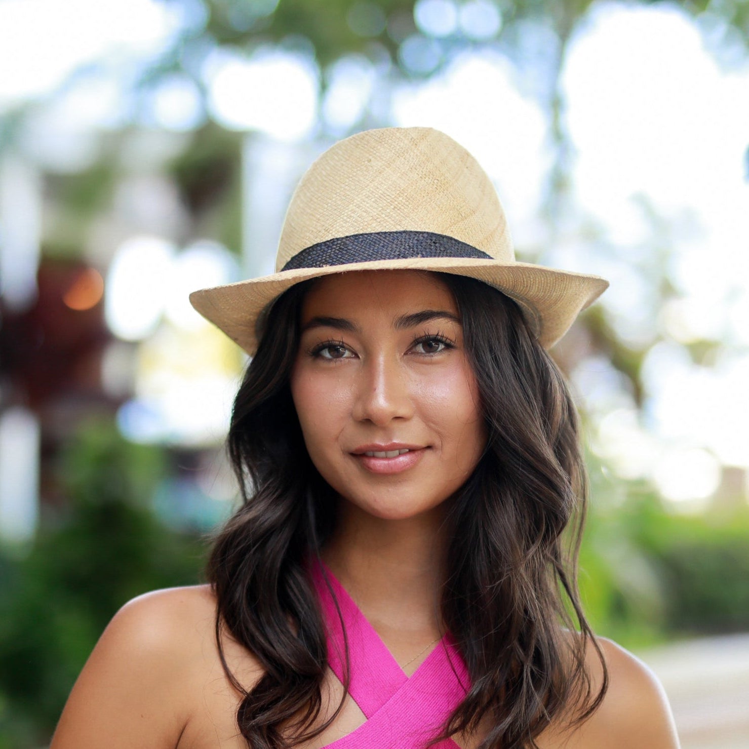 Model wearing Fedra Natural with Black Hat Band - Unisex Fedora Straw Hat handmade loomed natural raffia palm fiber in a solid hue of natural straw color with an attached black hat band - Shebobo