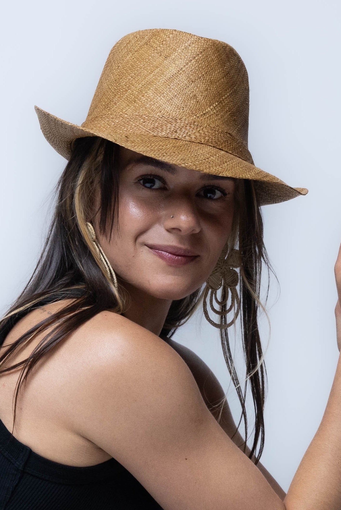 Model wearing Fedra 2" Brim Fedora Unisex Straw Hats Tobacco handmade loomed natural raffia palm fiber in a solid hue of tobacco cinnamon/dark/brown with an attached matching hat band - Shebobo