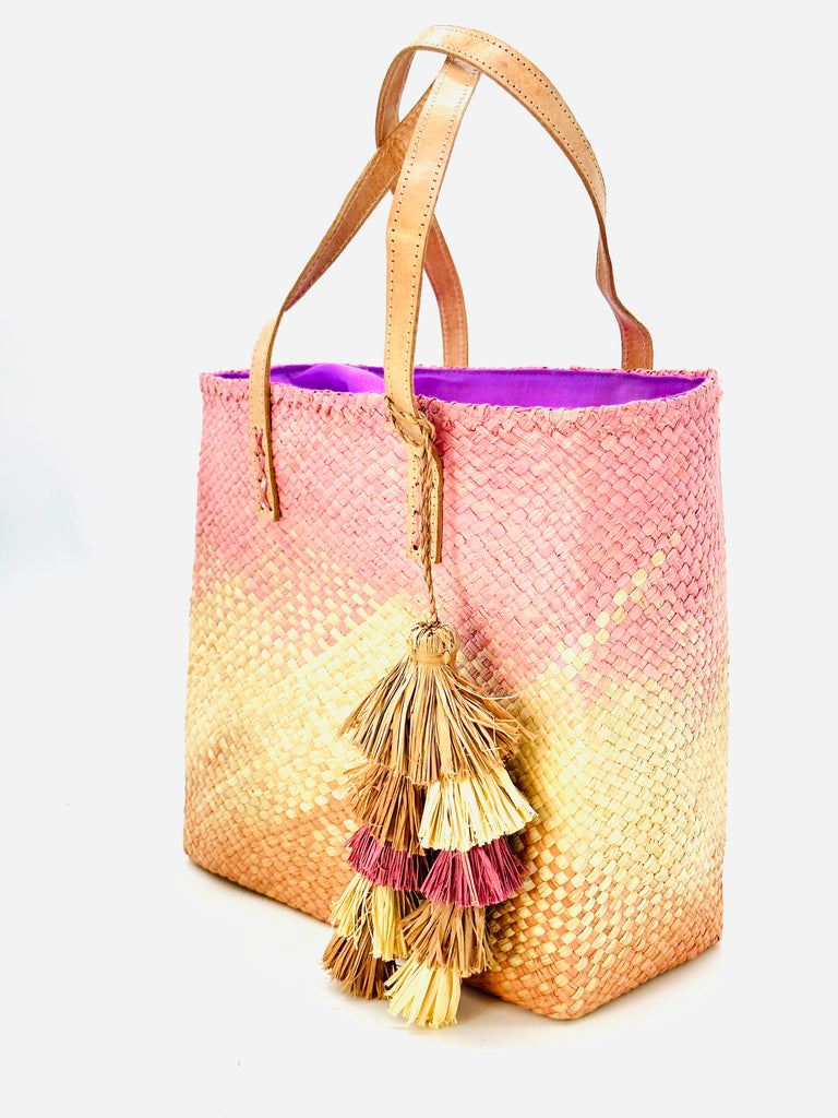 Side view of Holden Ombre Blush Straw Handbag Tassel Charm Embellishment handmade woven raffia dip dyed gradient of lavender pink/purple, natural, and blush orange/pink with matching multicolored, multi-tiered raffia tuft tassel - Shebobo