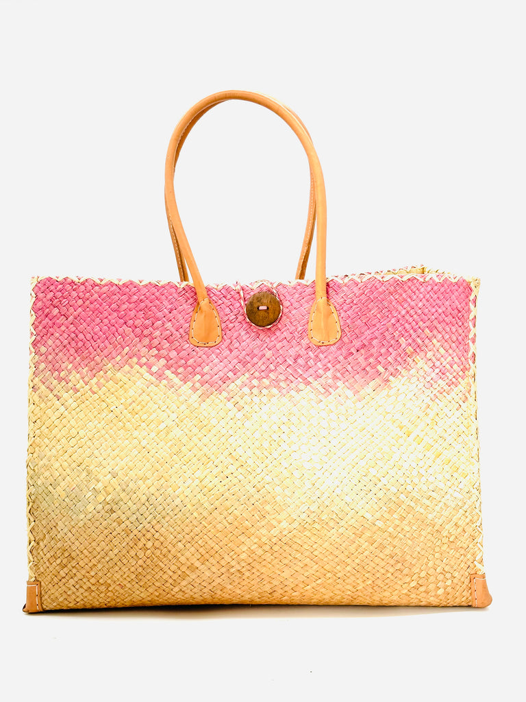 Holden Blush Ombre Zafran Large Straw Beach Bags handmade dip dyed raffia woven into a three part horizontal ombre pattern of lavender purple/pink on the top, natural in the middle and both sides, and blush orange/pink on the bottom with cross stitch edging, wooden button, and leather handles - Shebobo