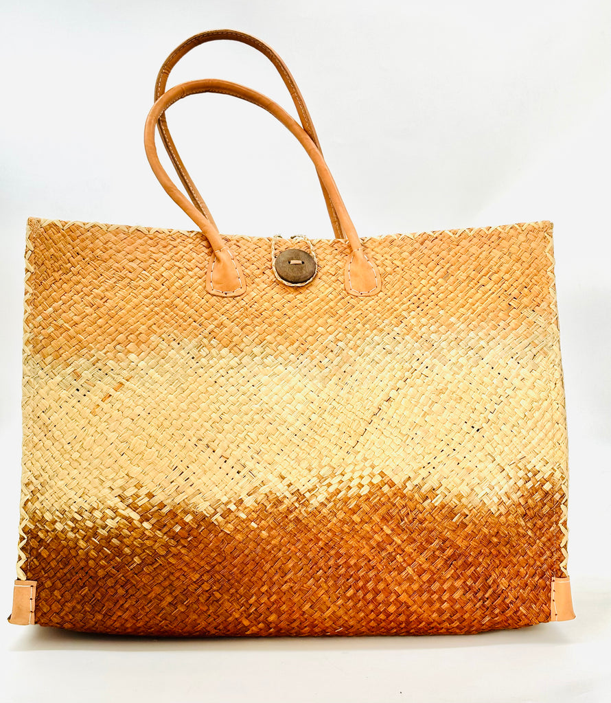 Holden Caramel Ombre Zafran Large Straw Beach Bags handmade dip dyed raffia woven into a three part horizontal ombre pattern of blush orange/pink on the top, natural in the middle and both sides, and blush caramel brown on the bottom with cross stitch edging, wooden button, and leather handles - Shebobo