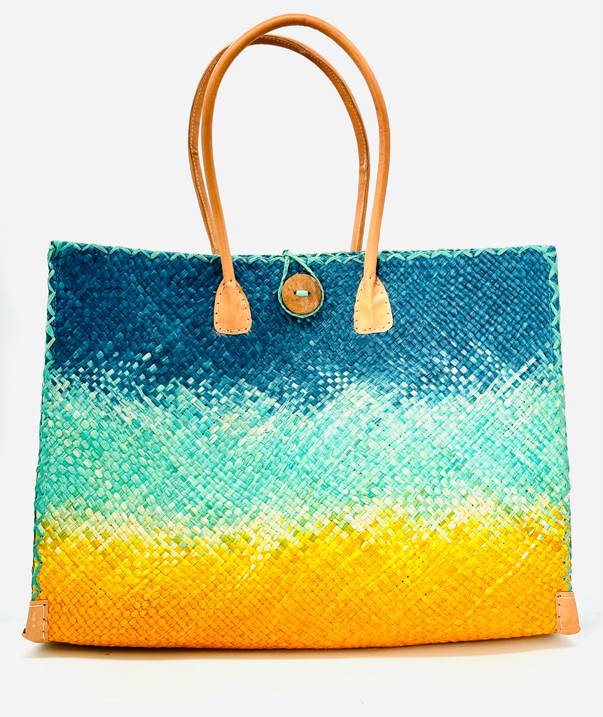 Holden Turquoise Ombre Zafran Large Straw Beach Bags handmade dip dyed raffia woven into a three part horizontal ombre pattern of turquoise blue on the top, seafoam blue/green in the middle and both sides, and saffron yellow on the bottom with cross stitch edging, wooden button, and leather handles - Shebobo