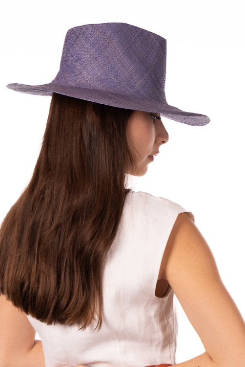 Model wearing Jamie Panama 3" brim handmade loomed raffia in a solid hue of denim retro/light/blue with attached matching hat band uv/sun protection lightweight breathable straw sun hat - Shebobo