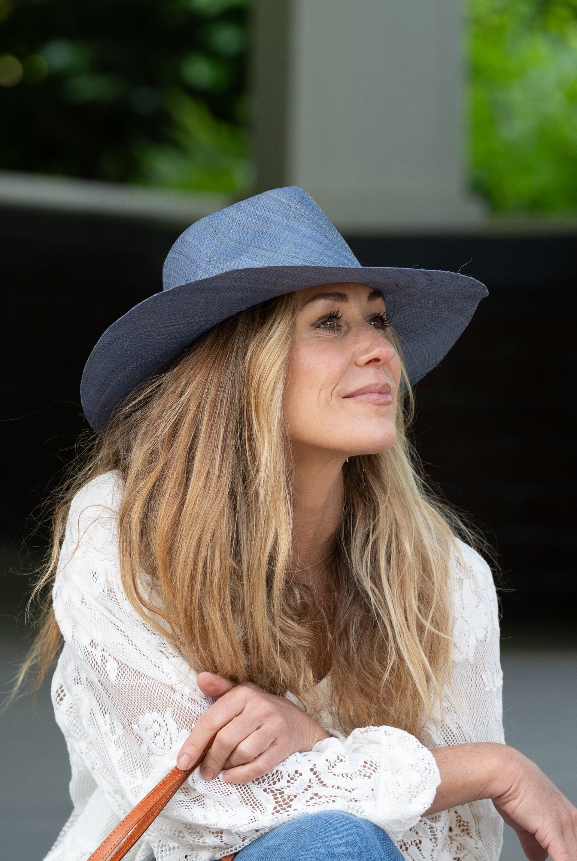 Model wearing Jamie Panama 3" brim handmade loomed raffia in a solid hue of denim retro/light/blue with attached matching hat band uv/sun protection lightweight breathable straw sun hat - Shebobo