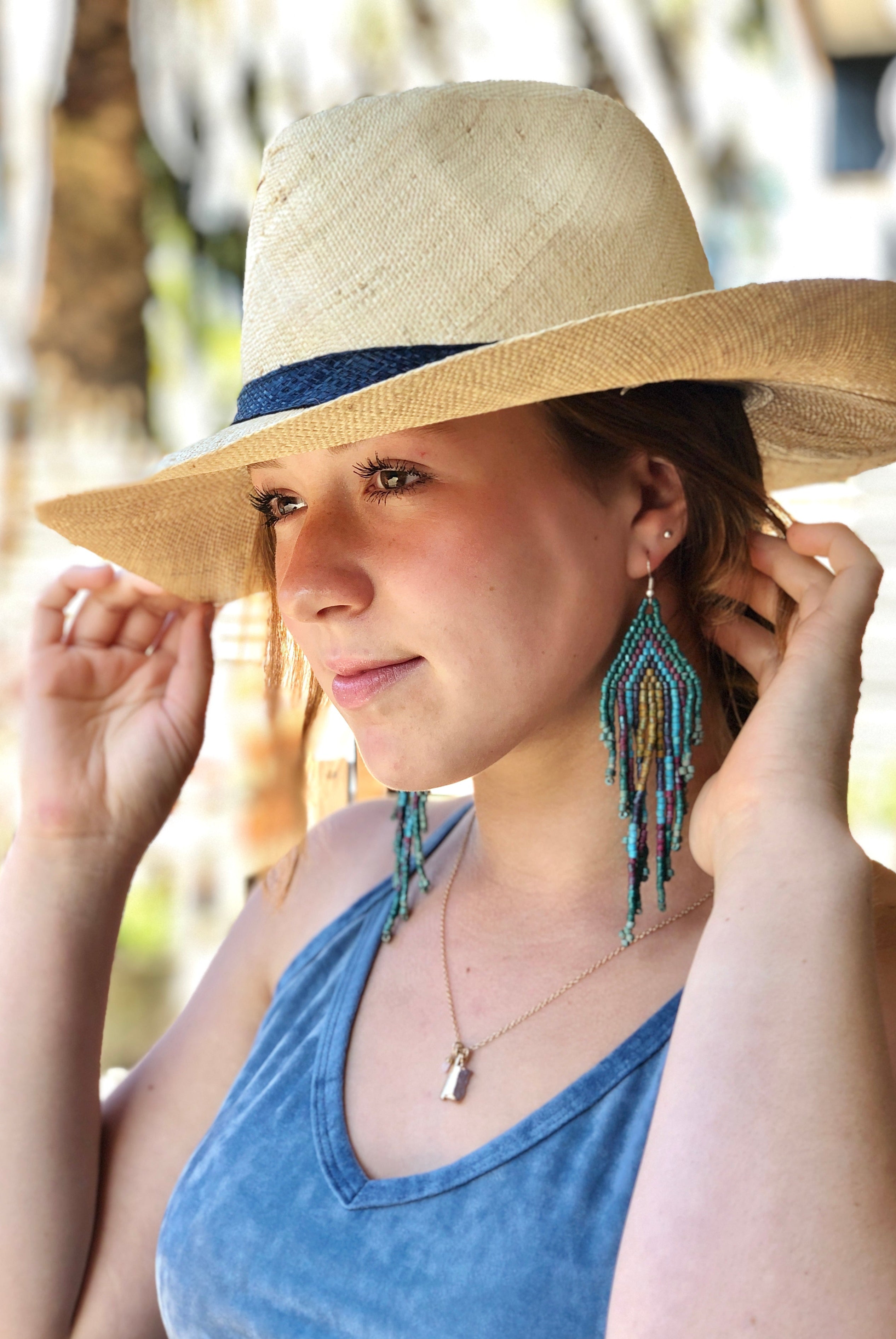 Model wearing Jamie Panama 3" brim handmade loomed raffia unisex straw sun hat in natural straw color with loomed black band - Shebobo