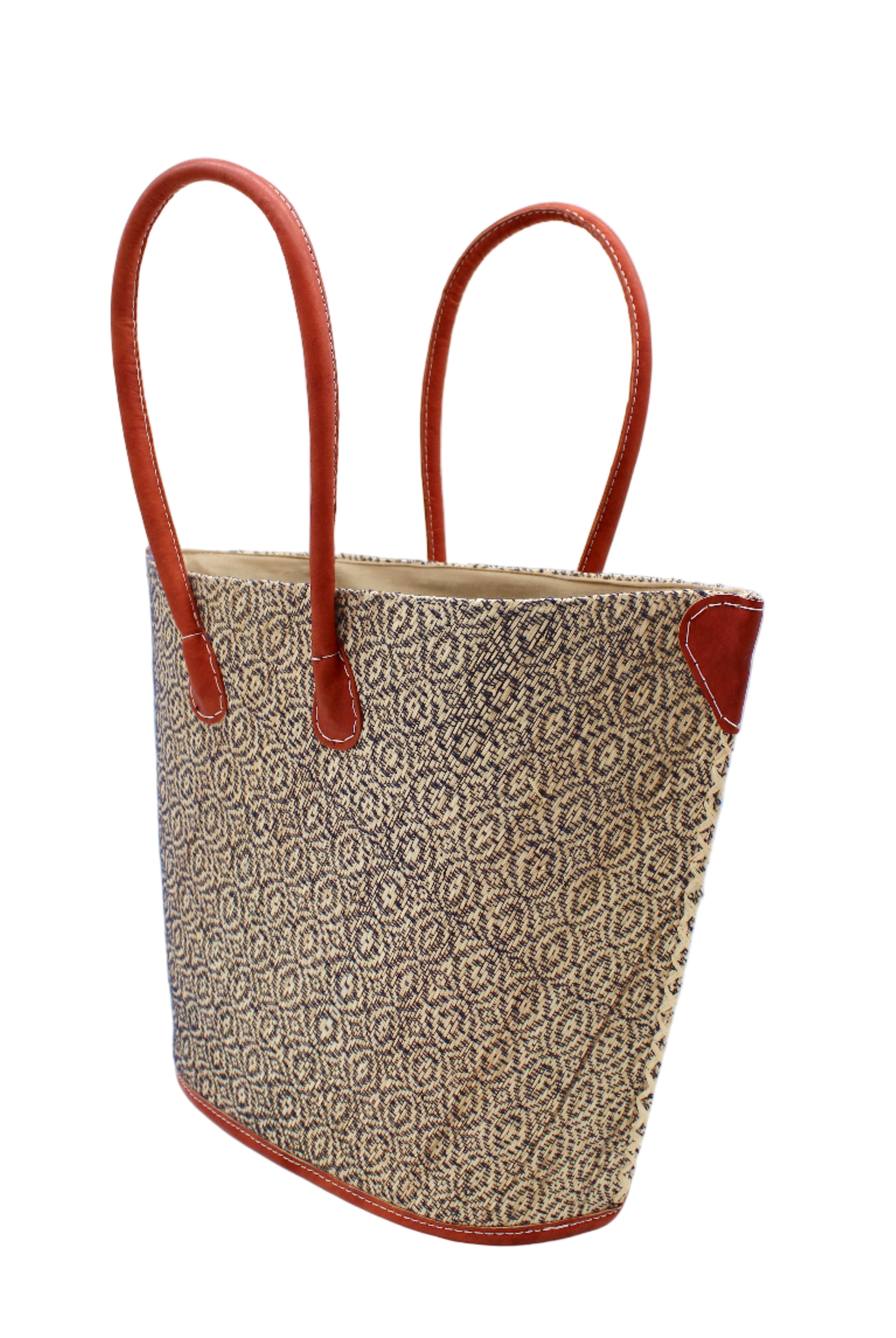 Side view Josephine Woven Small Straw Tote Bag handmade natural raffia palm fiber in natural straw color woven with contrasting Black thread stitching in a subtle diagonal stripe pattern consisting of bands of ovals and circles with natural cross-stitch edge and leather handles beach bag shoulder bag - Shebobo