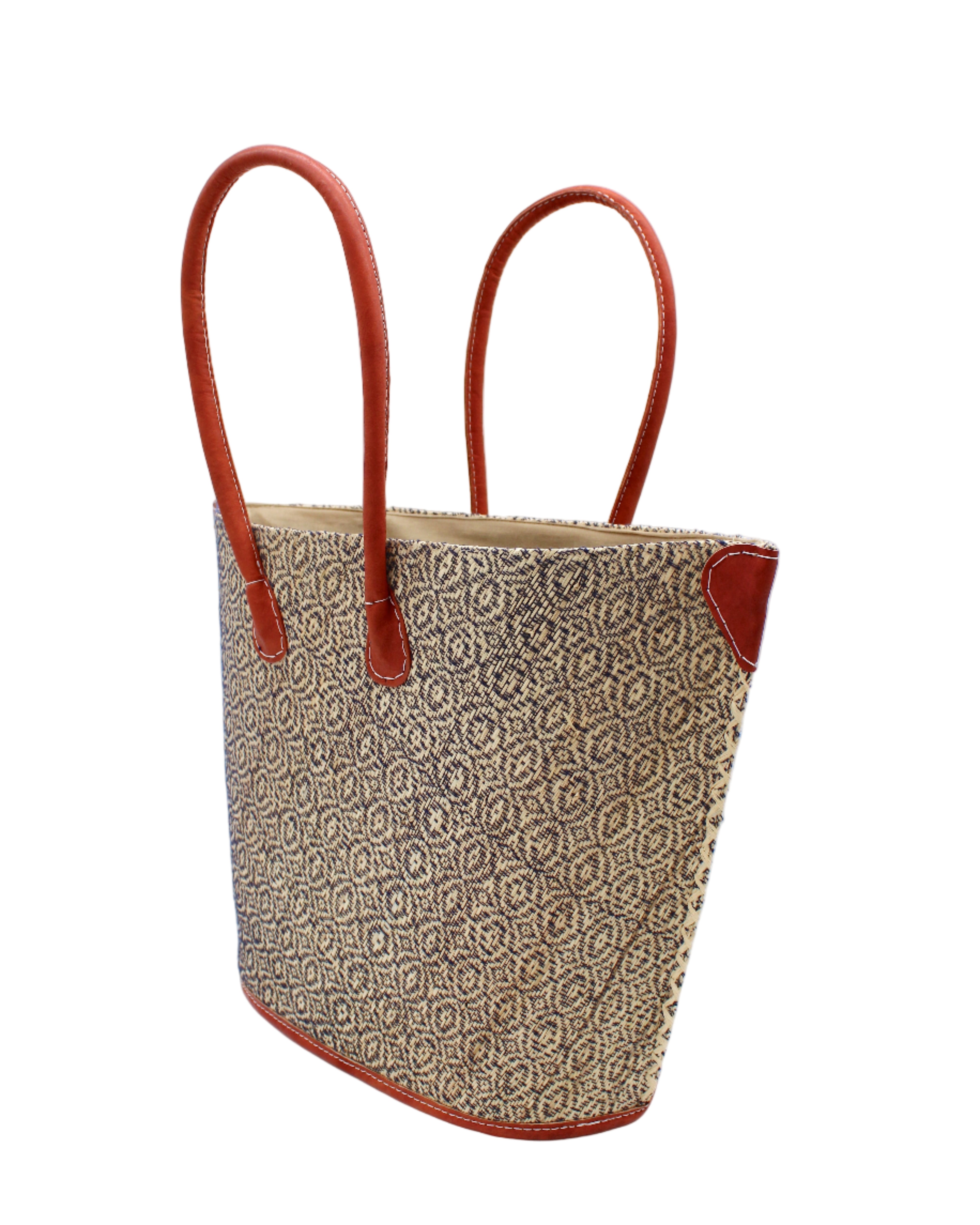 Side view Josephine Woven Small Straw Tote Bag handmade natural raffia palm fiber in natural straw color woven with contrasting Black thread stitching in a subtle diagonal stripe pattern consisting of bands of ovals and circles with natural cross-stitch edge and leather handles beach bag shoulder bag - Shebobo