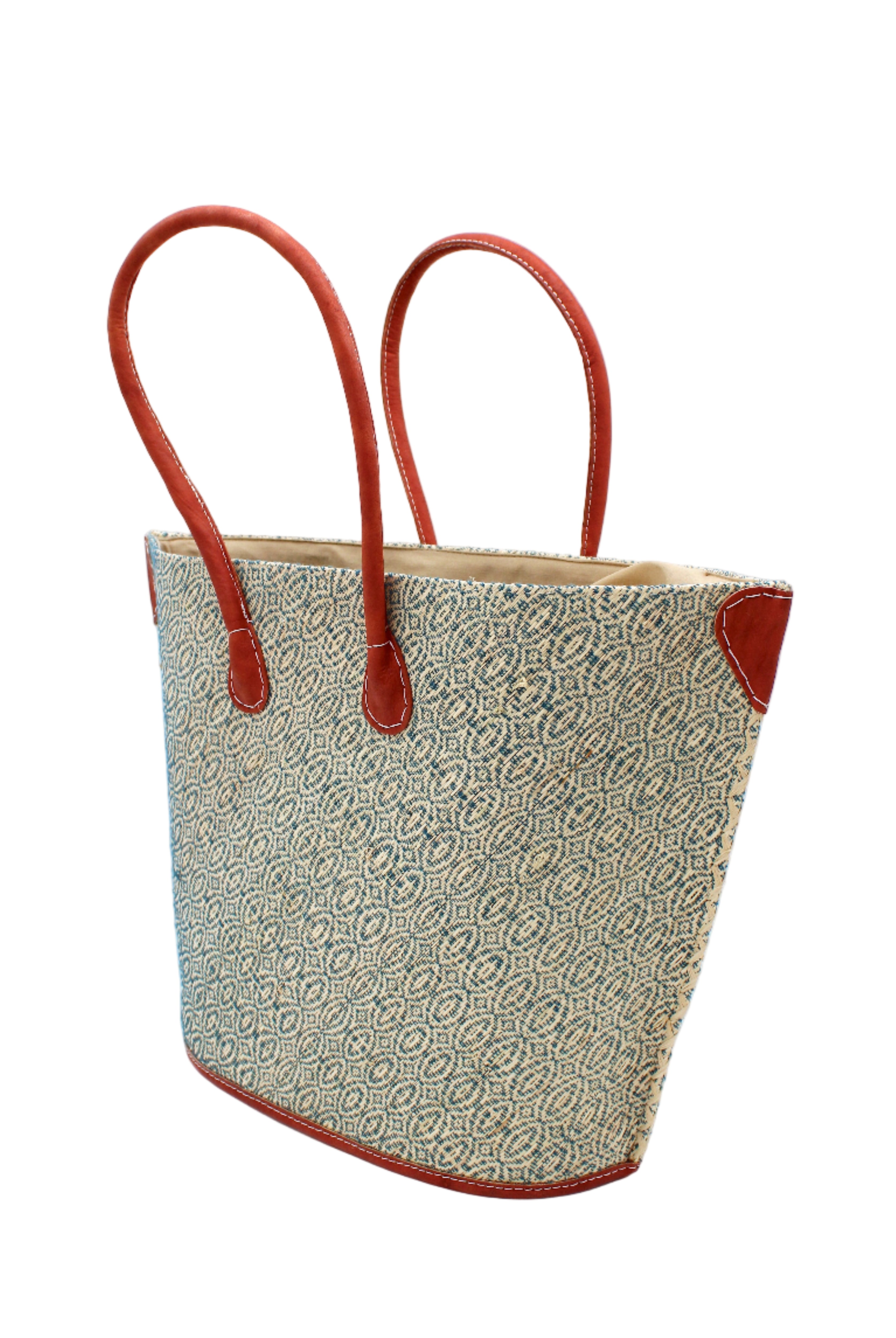 Side view Josephine Woven Small Straw Tote Bag handmade natural raffia palm fiber in natural straw color woven with contrasting Turquoise blue/green thread stitching in a subtle diagonal stripe pattern consisting of bands of ovals and circles with natural cross-stitch edge and leather handles beach bag shoulder bag - Shebobo