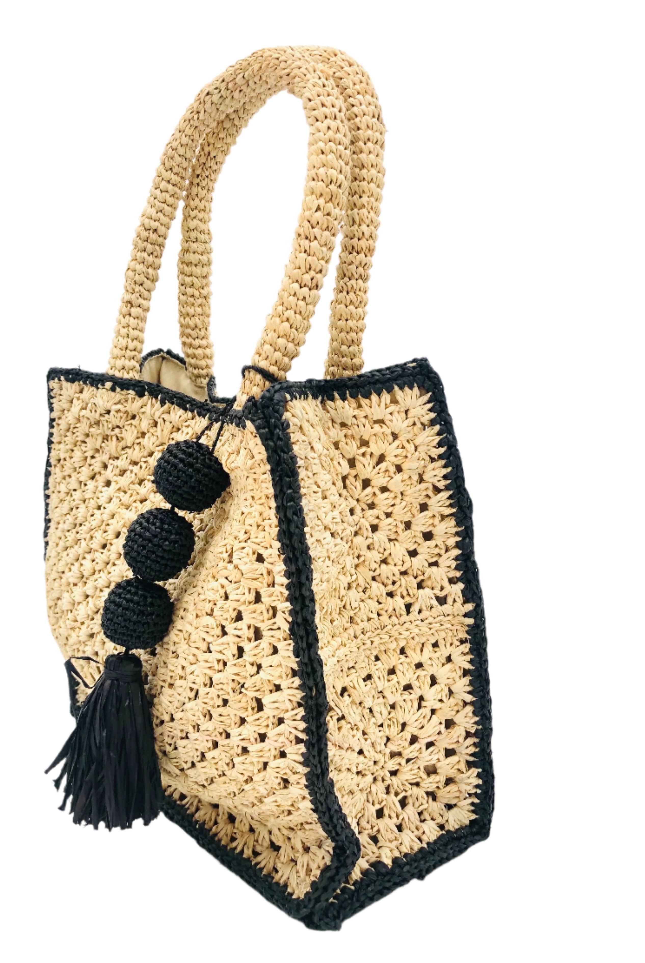 Side view Kimba handmade crochet two tone handbag purse natural straw color with black trim and crochet cascading balls plus tassel bag charm embellishment - Shebobo