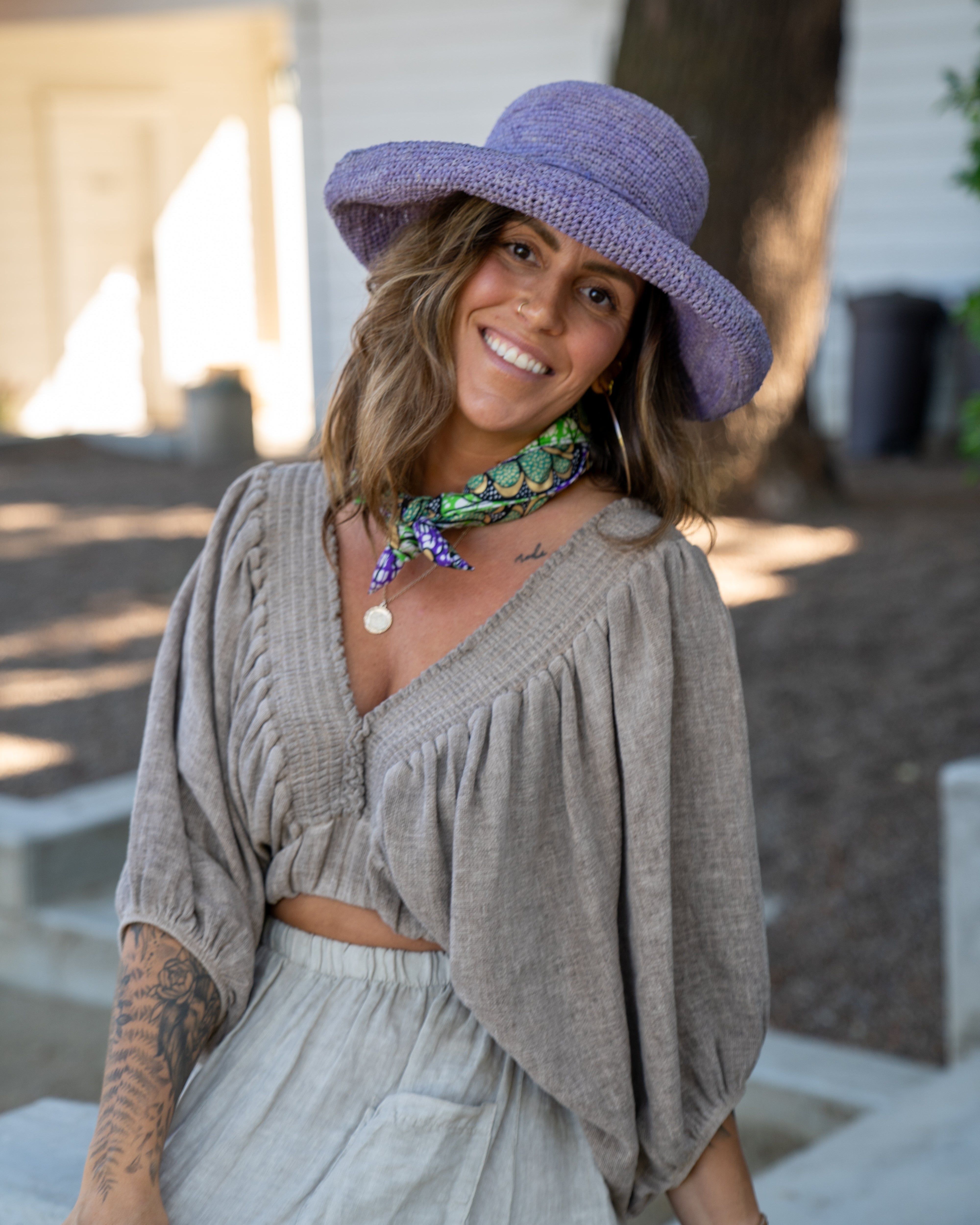 Model wearing Kamari African Print Wax Cloth Multicolor bright bold fun assorted print double layer bandanas can be worn as headbands or kerchief - Shebobo (with Leor 3" Brim Crochet Straw Sun Hats)