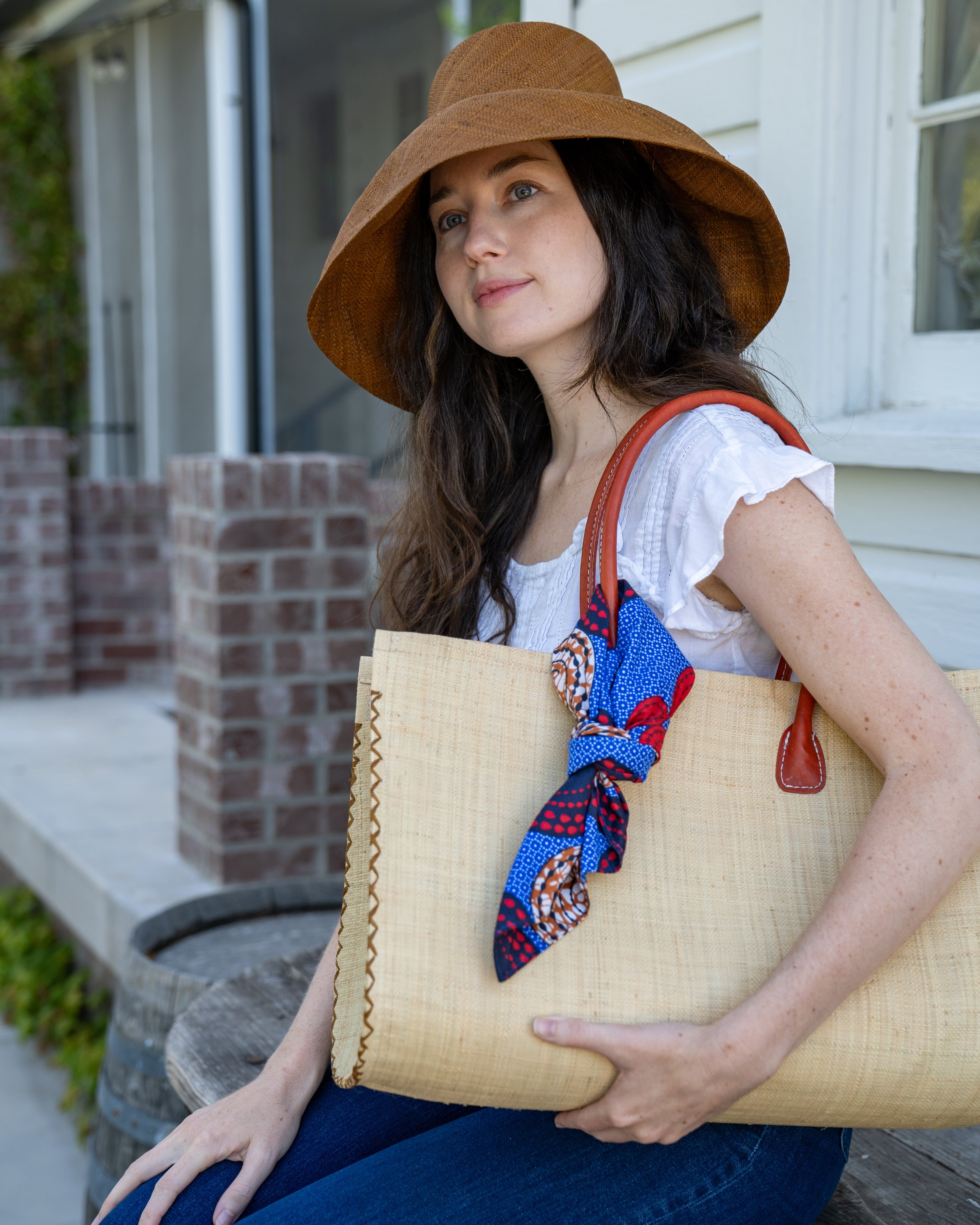 Model wearing bag embellishment Kamari African Print Wax Cloth Multicolor bright bold fun assorted print double layer bandanas can be worn as headbands or kerchief - Shebobo (Monica 5" & 7" Wide Brim Solid Color Packable Straw Sun Hats)