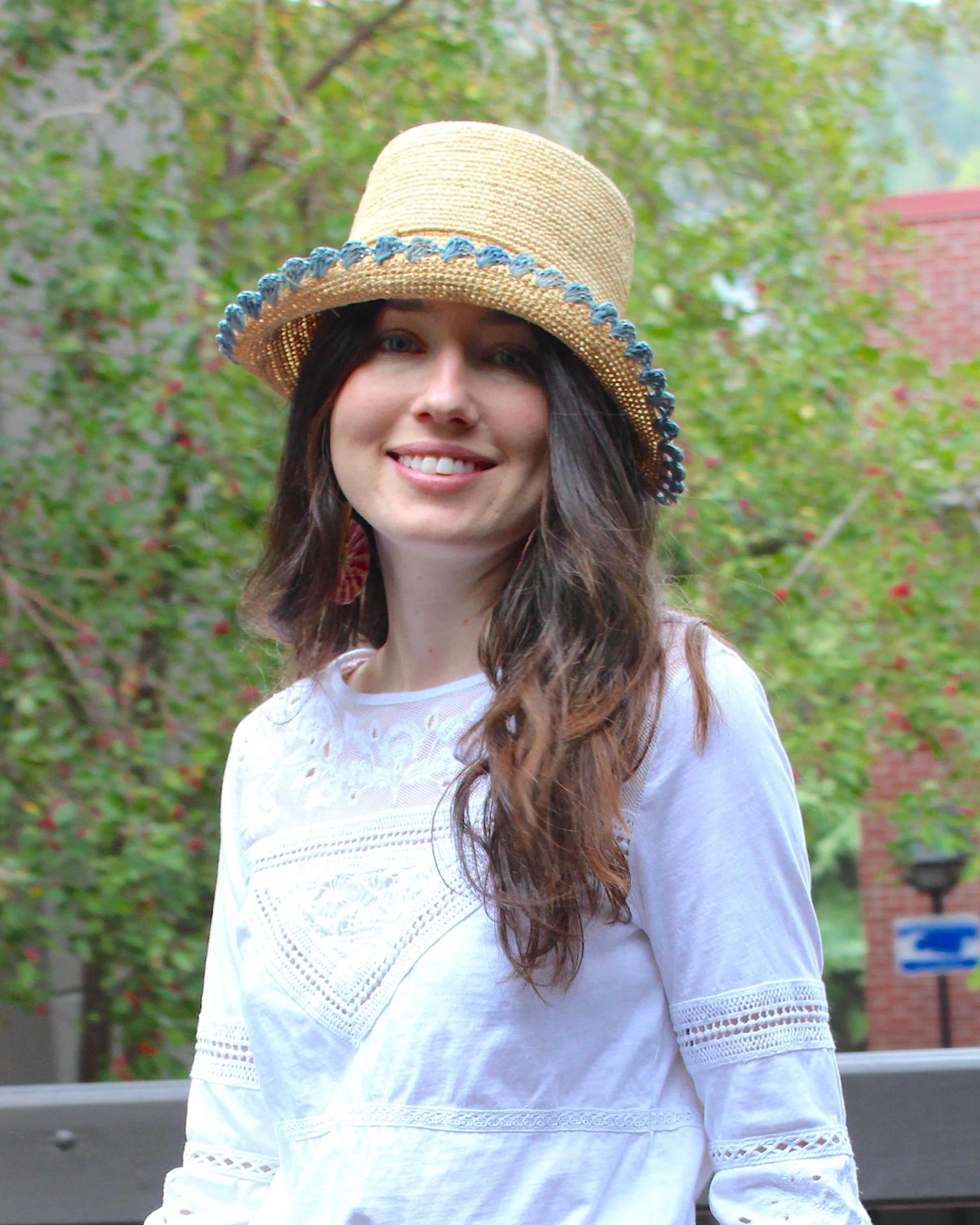 Model wearing Kate Natural with Denim Crochet Bucket Straw Hats with Colored Lace Weave Edge handmade woven raffia palm fiber in a solid hue of natural straw color in a subtle link texture with denim retro/light/blue lace weave floral edge trim around the outer brim two tone multicolor uv protection hat - Shebobo