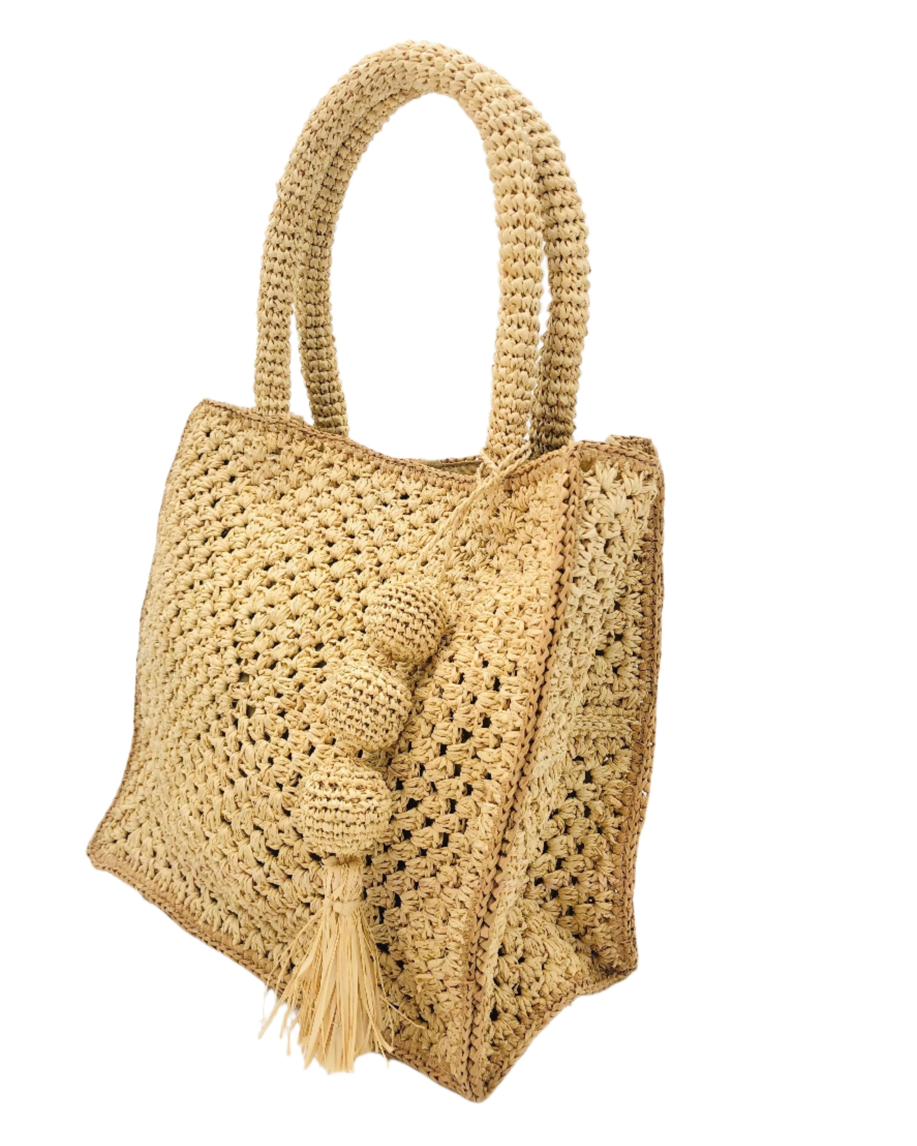 Side view of Kimba Crochet Handbag with Sphere Tassel Charm Embellishment handmade natural raffia palm fibers crochet into a granny square pattern with cappuccino/light brown detail edging - Shebobo