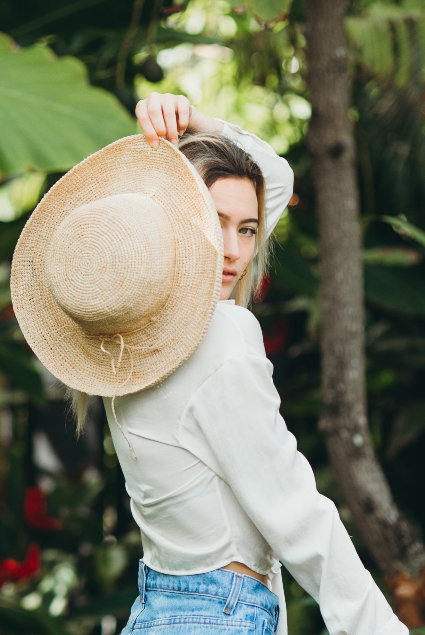 Model wearing Leor crochet straw hat handmade natural straw color raffia 3" brim packable straw hat - Shebobo