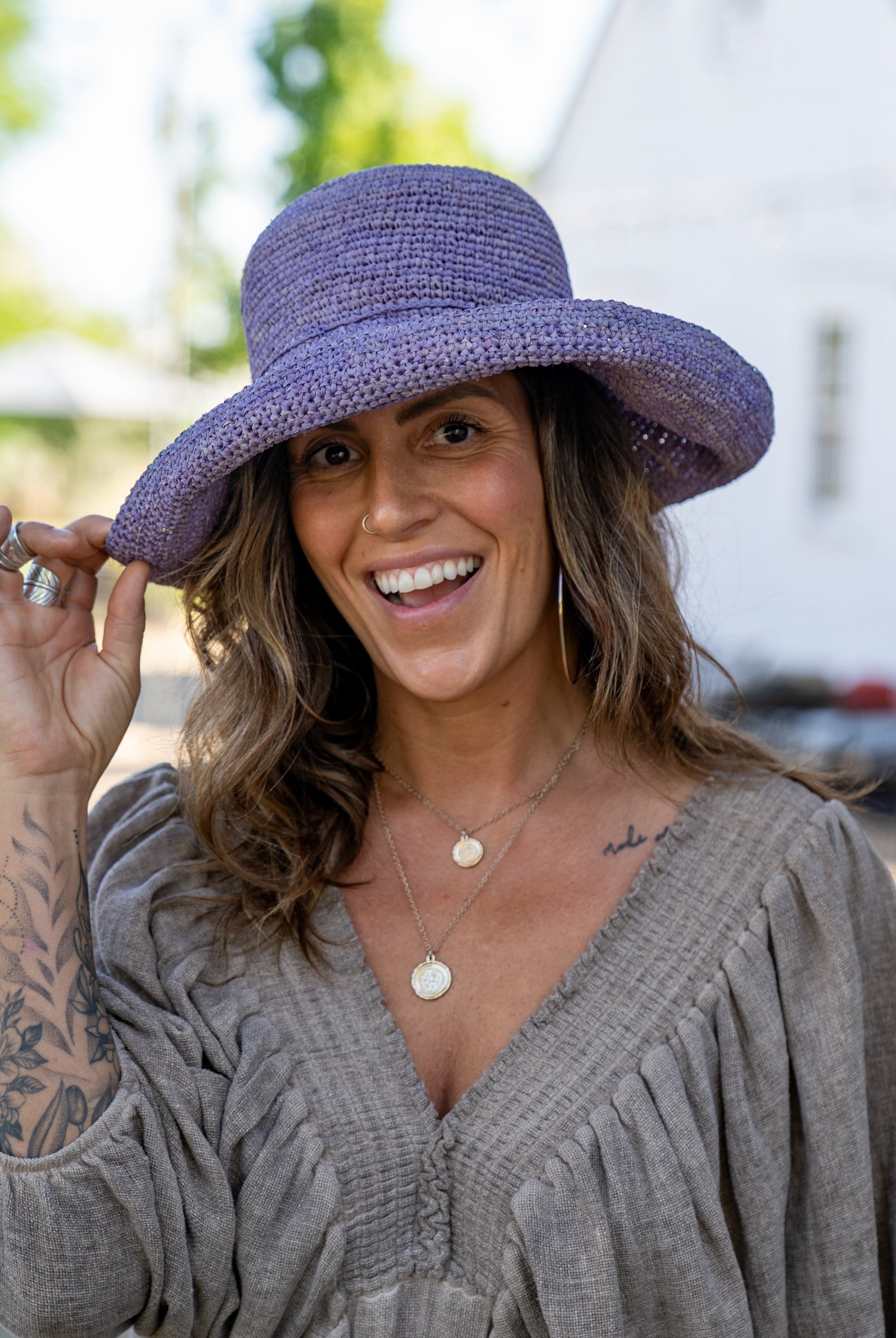 Model wearing Leor Wisteria crochet straw hat handmade wisteria/lilac/lavender/pale purple color raffia 3" brim packable straw hat with matching adjustable braided hat band - Shebobo