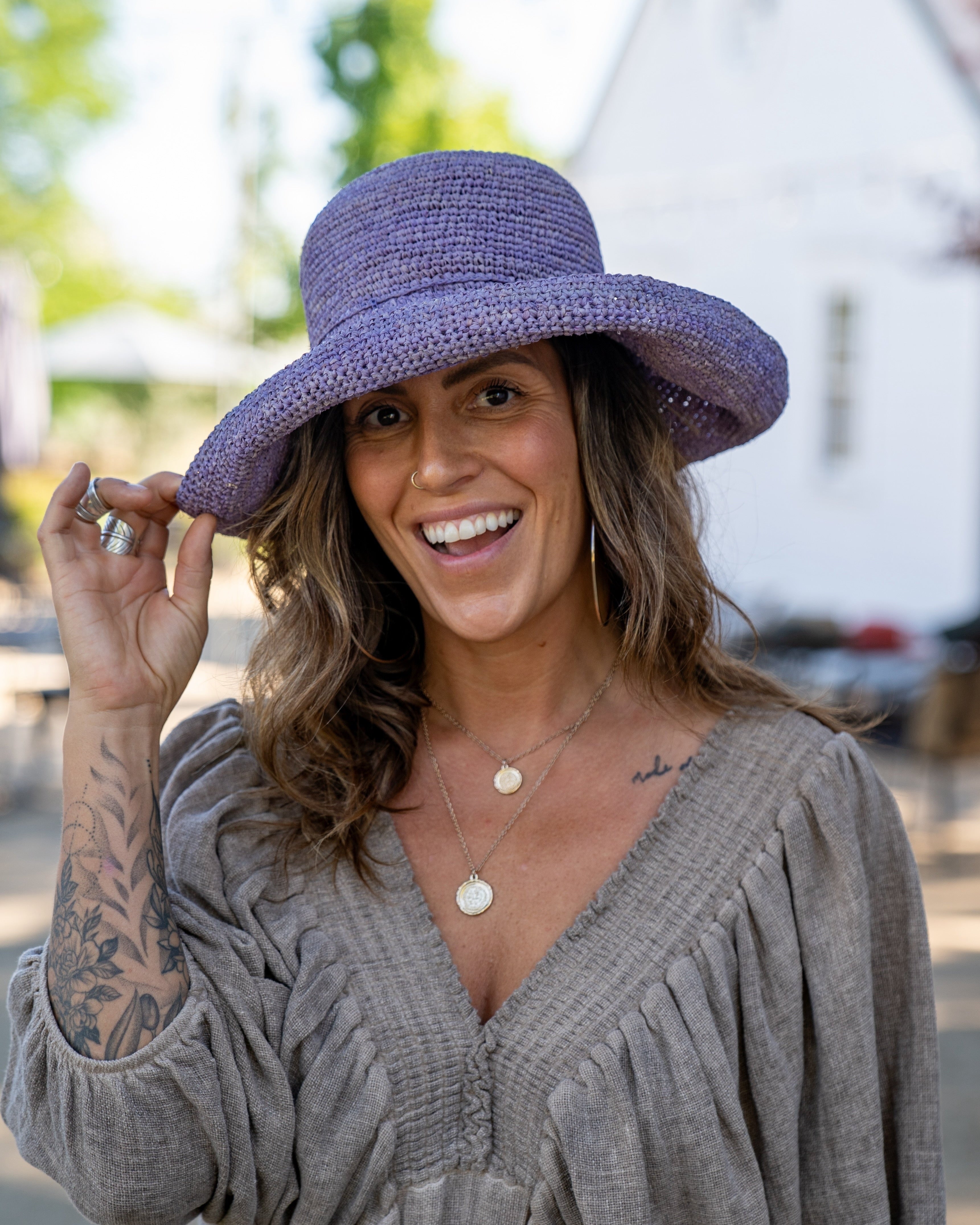 Model wearing Leor Wisteria crochet straw hat handmade wisteria/lilac/lavender/pale purple color raffia 3" brim packable straw hat with matching adjustable braided hat band - Shebobo