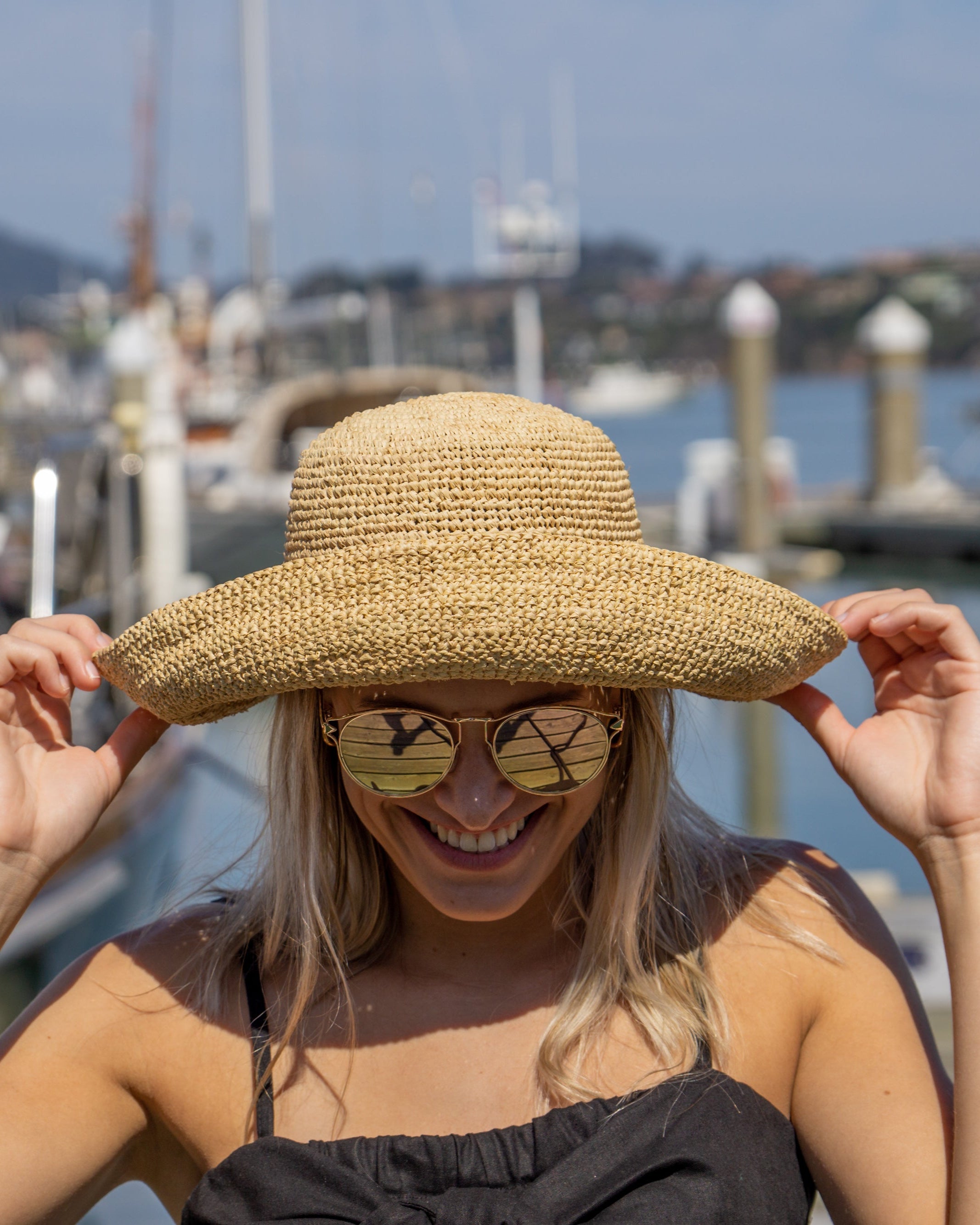Model wearing Leor Natural crochet straw hat handmade natural straw color raffia 3" brim packable straw hat with matching adjustable braided hat band - Shebobo