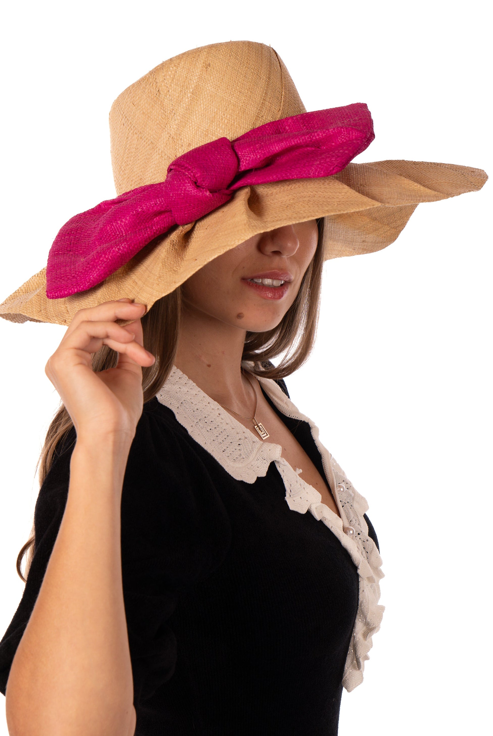 Model wearing Lilly 5" Brim Fan Straw Sun Hat with Big Fuchsia bright/hot/barbie/pink bow and matching hatband on handmade natural loomed raffia pleated wide brim hat - Shebobo