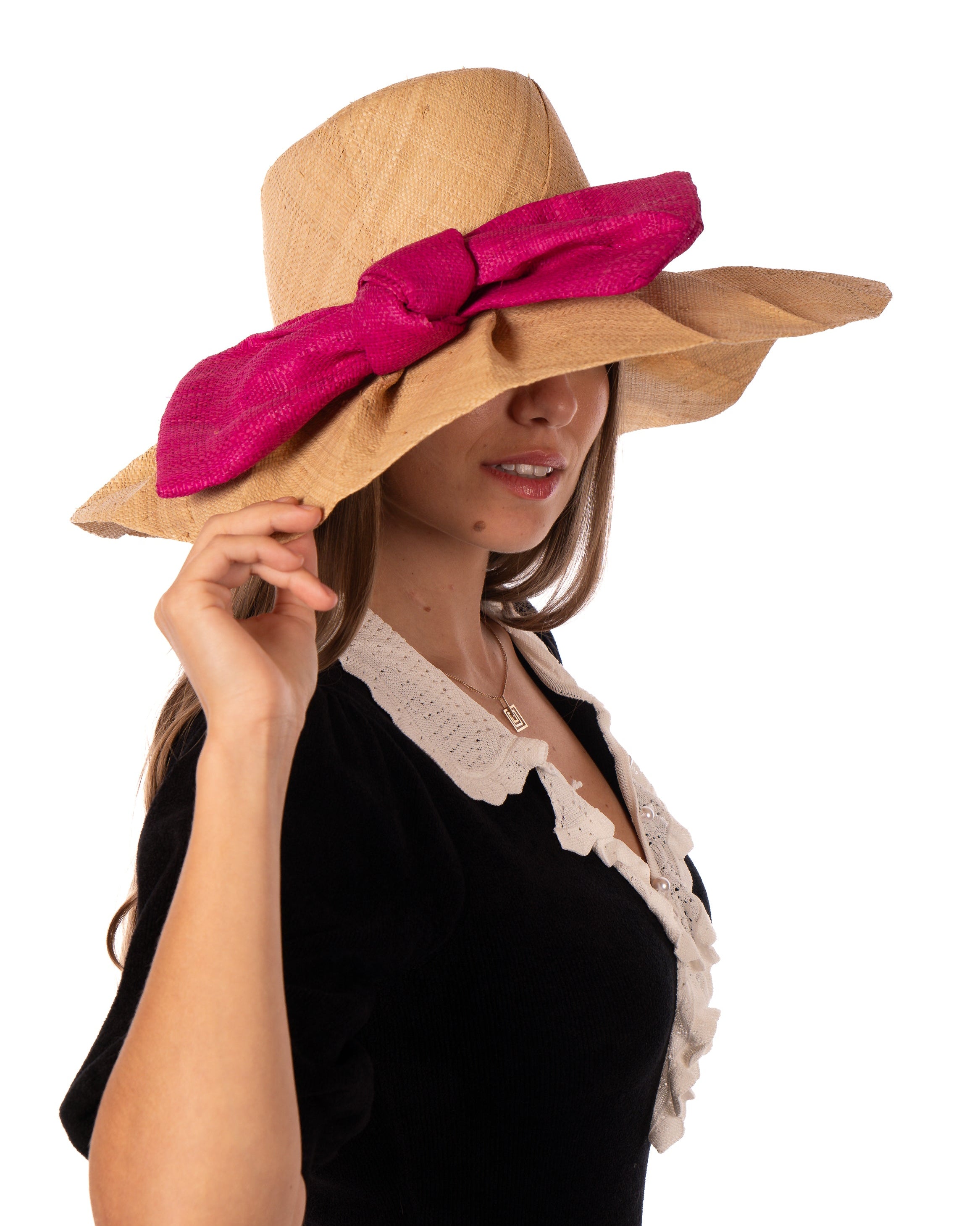 Model wearing Lilly 5" Brim Fan Straw Sun Hat with Big Fuchsia bright/hot/barbie/pink bow and matching hatband on handmade natural loomed raffia pleated wide brim hat - Shebobo
