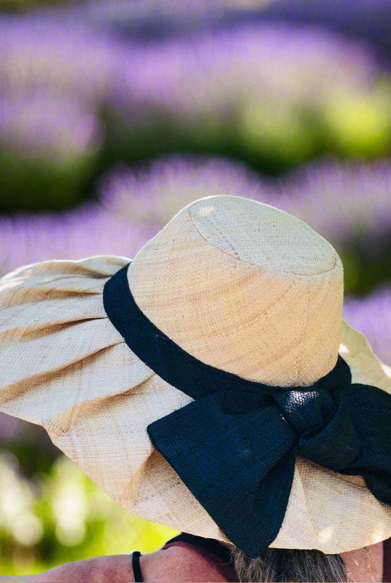 Model wearing Lilly 5" Brim Fan Straw Sun Hat with Big Black bow and matching hatband handmade natural loomed raffia pleated wide brim - Shebobo