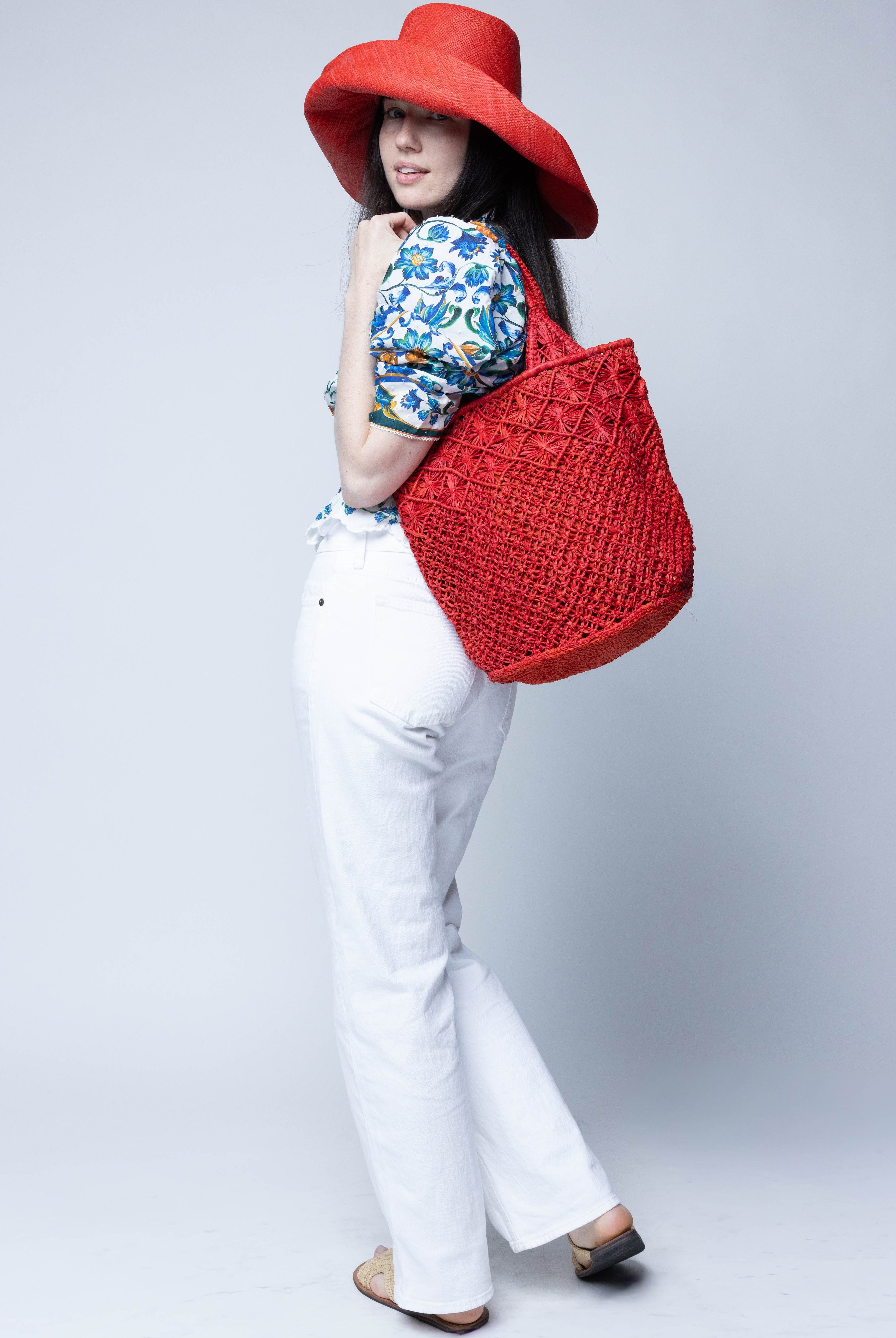 Luca Macrame Diamonds Crochet Straw Handbag handmade knotted natural raffia palm fiber in a solid hue of Coral red/orange in a multi-texture circular pattern of concentric spiral links on the base, cross-hatch x pattern up 2/3rds of the bag, and geometric diamond flower pattern around the top third, with diamond pattern on the base of the shoulder strap handles with tubular loop handle tops - Shebobo (with Monica 5" & 7" Wide Brim Solid Color Packable Straw Sun Hats)