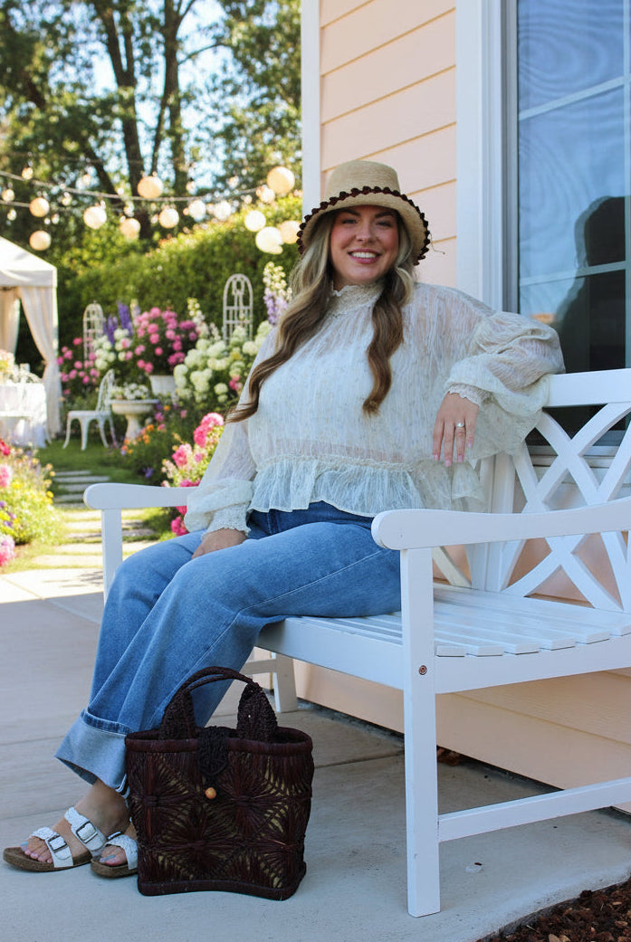 Model wearing Small size Lusha Macrame Diamond and Crochet Straw Basket Bag handmade natural raffia palm fiber in a solid hue of umberwine bordeaux/burgundy/claret/dark/purple/red macrame into a large geometric diagonal diamond pattern with loop banding on the top and bottom edges, macrame diamond and loop handles, with knotted matching flap closure beach bag shoulder bag purse - Shebobo (with Cara 3" Brim Bucket Straw Sun Hats with Big Bow)
