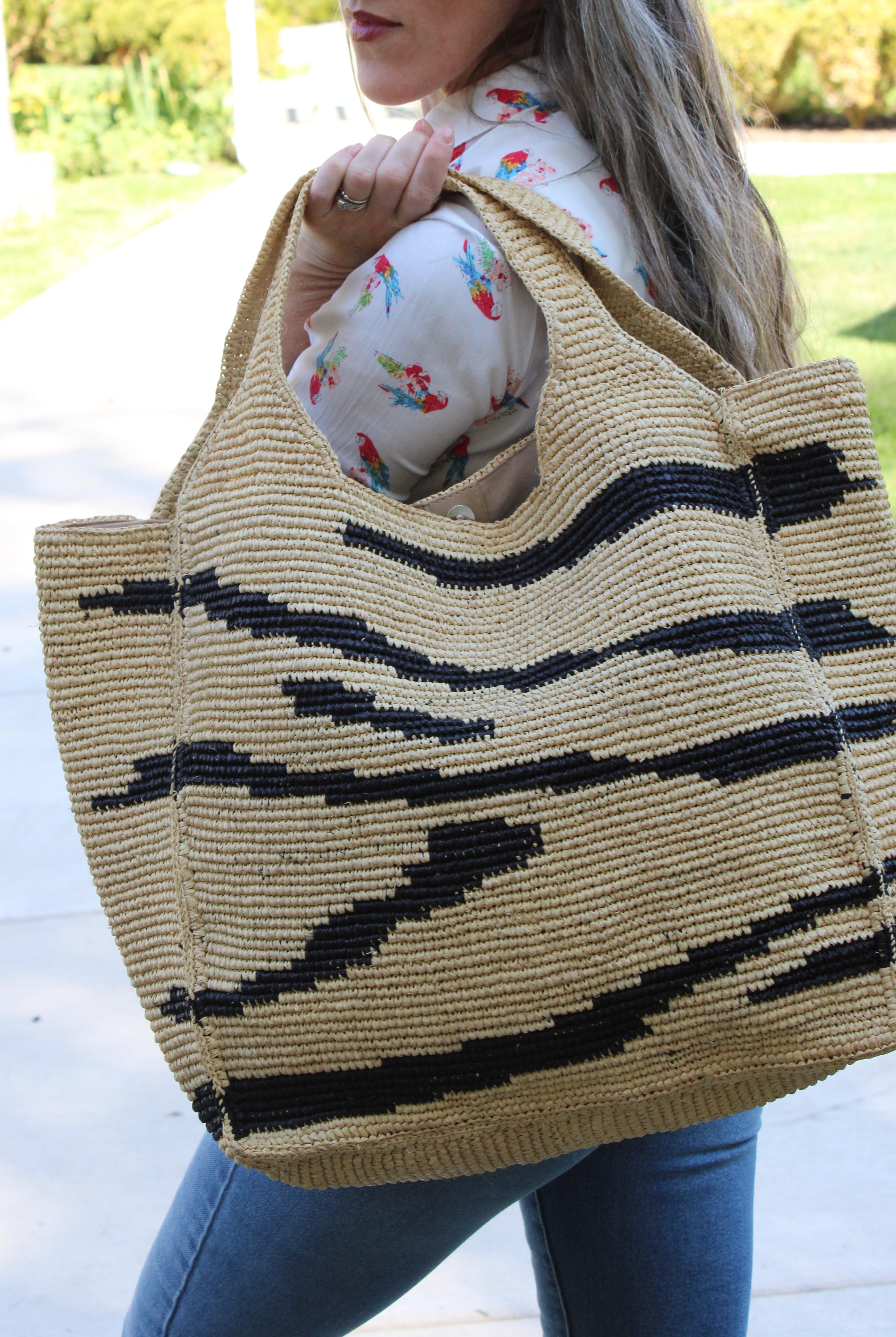 Model wearing Mamie XL Crochet Straw Basket Handbag handmade crochet natural raffia palm fiber in a two tone natural and black zebra stripe pattern purse beach bag - Shebobo