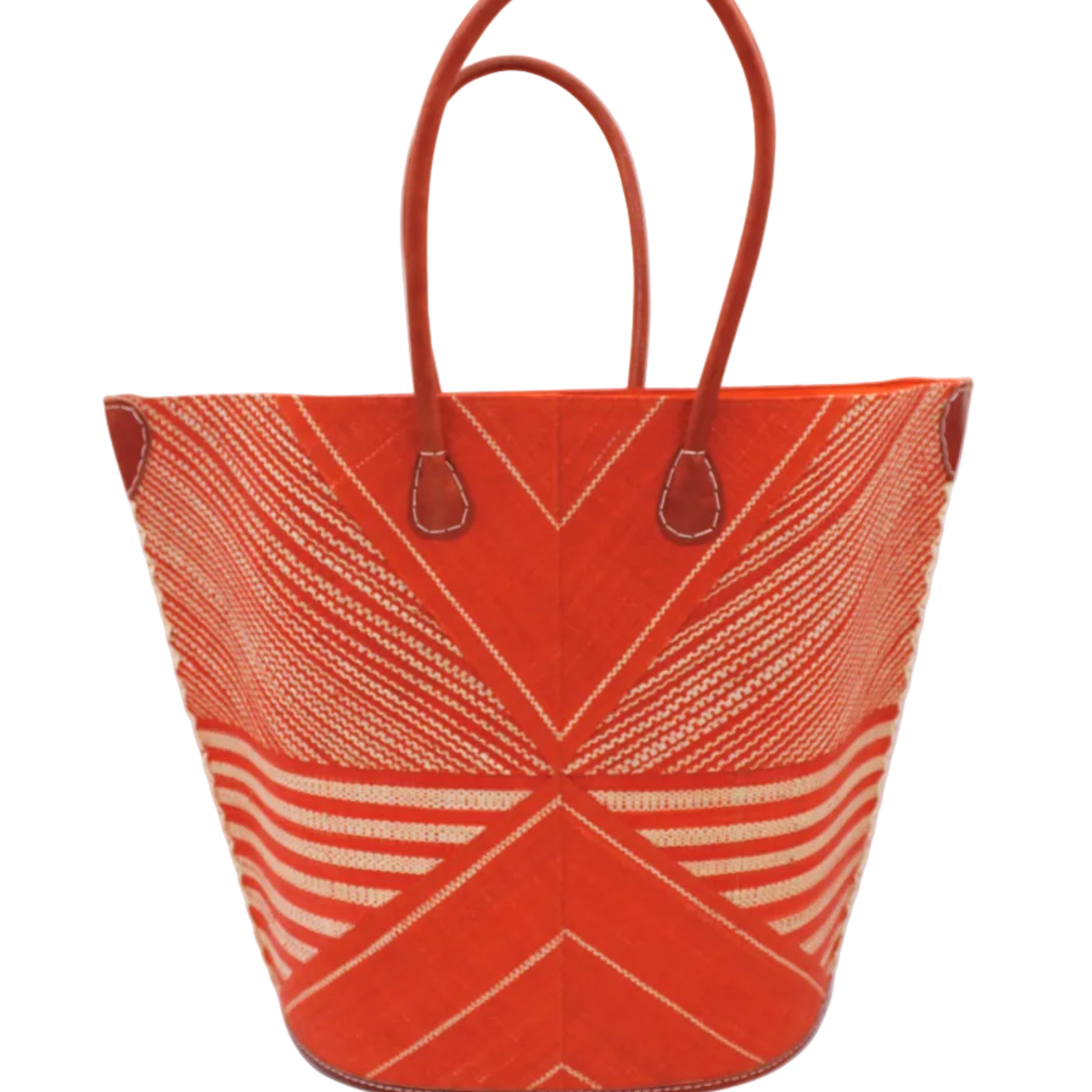 Mariposa Large Straw Tote Bag handmade loomed natural raffia palm fiber in a multi paneled pattern design of pinstripe, melange, and wide stripe combinations geometrically radiating from the center point of the bag outwards in a two tone color combination of Coral orange/red and natural straw color with a solid hue of color on the back of the bag plus leather handles and embellishments shoulder bag - Shebobo