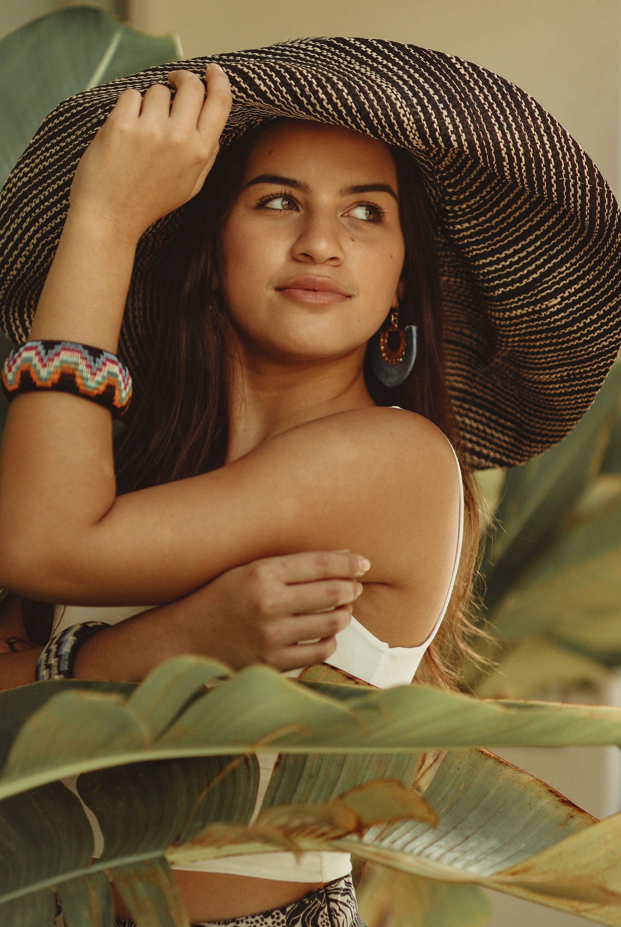 Model wearing Monica 7 inch Wide Brim Black Two Tone Melange Packable Straw Sun Hat handmade loomed raffia in a multicolor heathered melange pattern of black and natural straw color creates a subtle swirl - Shebobo