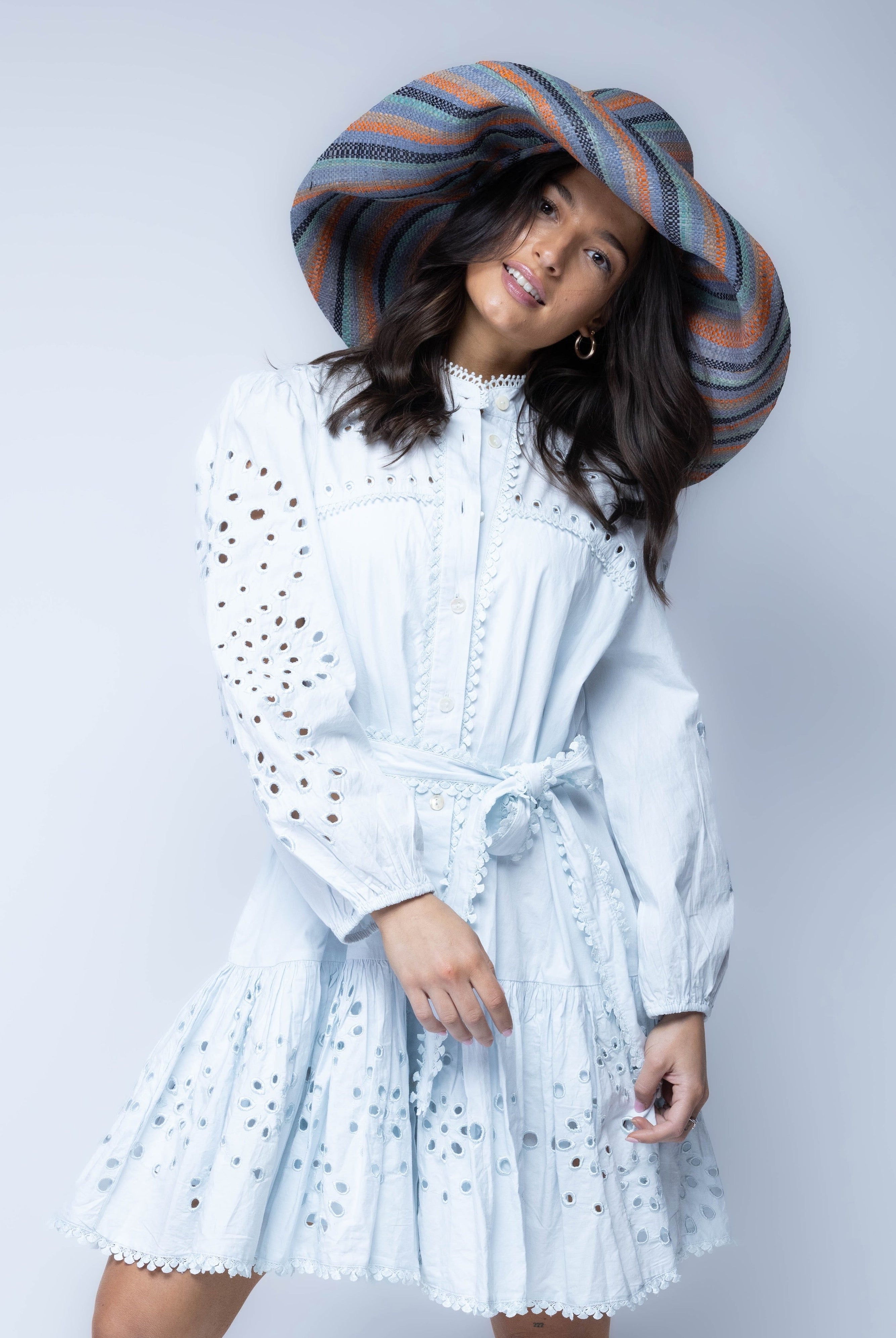 Model wearing Monica 7" Wide Brim Cloudberry Swirl Multicolor Stripes Packable Straw Sun Hat handmade loomed raffia in bands of coral orange/red, denim retro/light/blue, seafoam light/blue/green, black, cappuccino tea/light/brown stripes create a swirl pattern - Shebobo