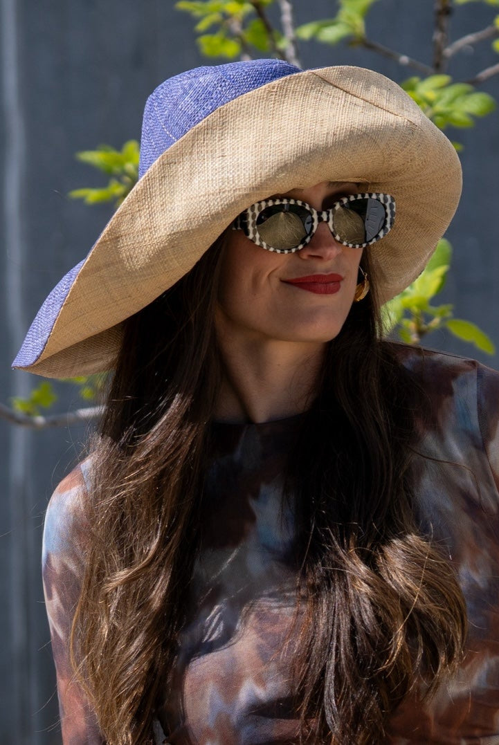 Model wearingMonica 7" Brim Two Tone Denim Straw Hat handmade loomed raffia color block pattern of the top half denim retro/light/blue and the bottom half natural straw color - Shebobo