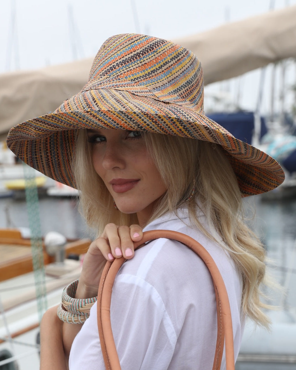 Model wearing Monica 5" Wide Brim Blush Multi Melange Packable Straw Sun Hat handmade loomed raffia multicolor heathered swirl pattern of orange, blush pink, natural, blue, brown, yellow, etc. - Shebobo