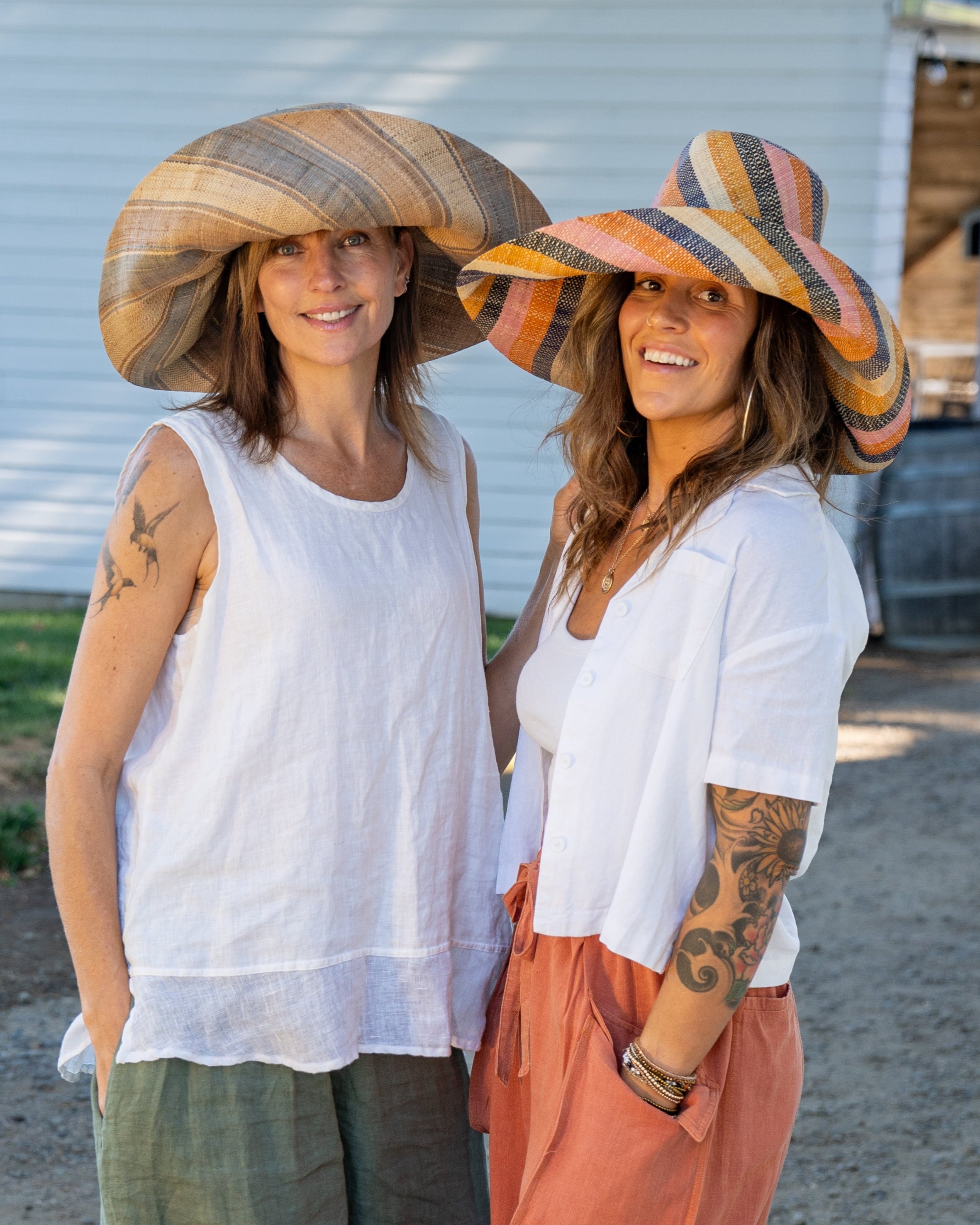 Model wearing Monica 7" Wide Brim Latte Swirl and Candyland Stripe Multicolor Stripes Packable Straw Sun Hat Handmade loomed raffia in multi width bands of color create a swirl pattern - Shebobo