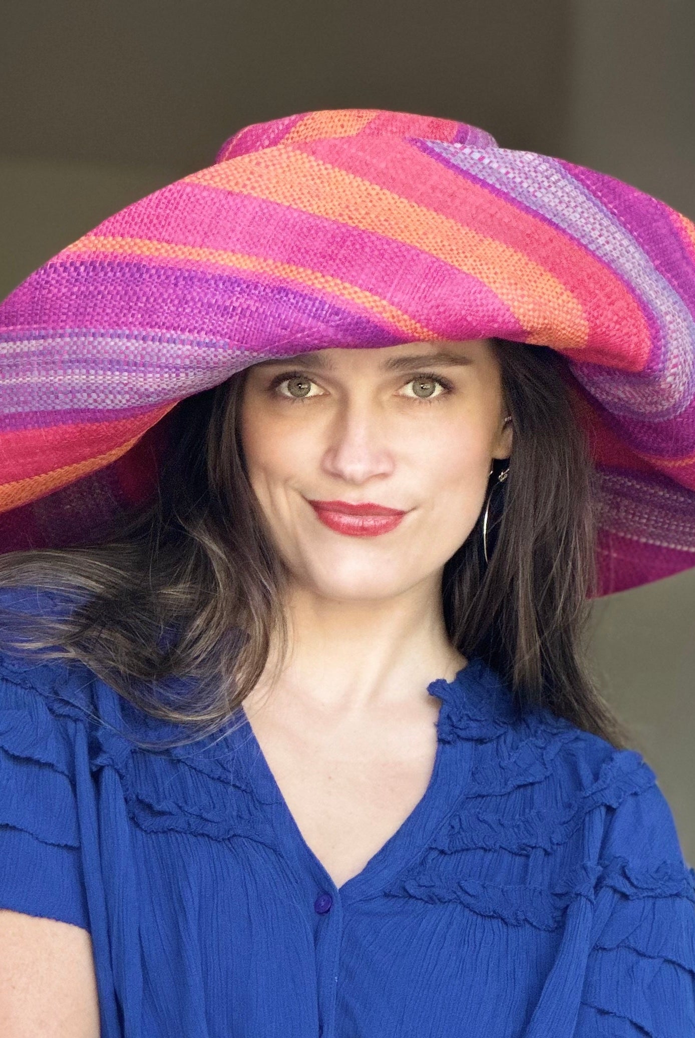 Model wearing Monica 7" Wide Brim Sherbert Swirl Multicolor Stripes Packable Straw Sun Hat Handmade loomed raffia in multi width bands of saffron yellow, fuchsia pink, blue, purple, orange, red, etc. create a swirl pattern - Shebobo