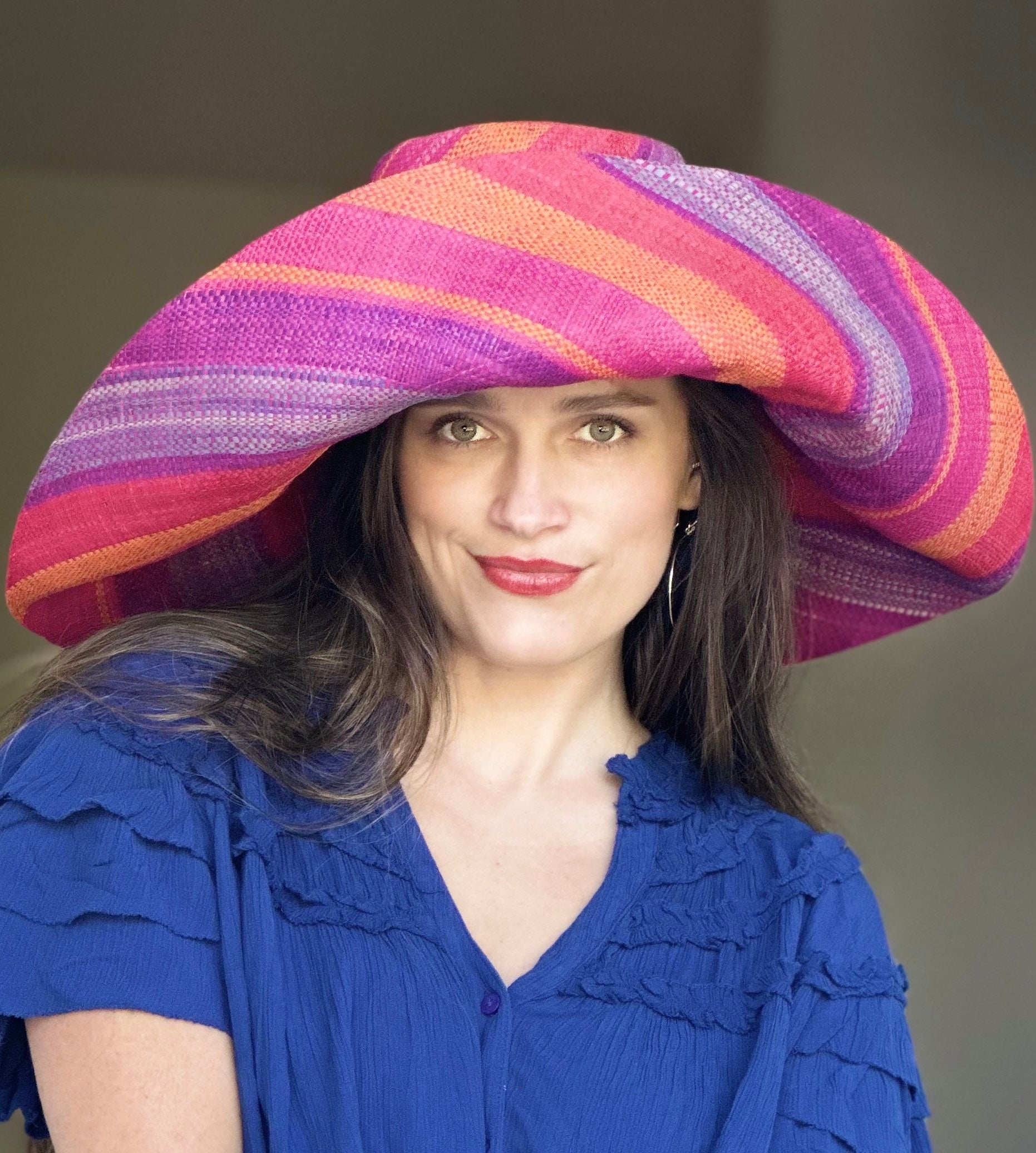 Model wearing Monica 7" Wide Brim Sherbert Swirl Multicolor Stripes Packable Straw Sun Hat Handmade loomed raffia in multi width bands of saffron yellow, fuchsia pink, blue, purple, orange, red, etc. create a swirl pattern - Shebobo