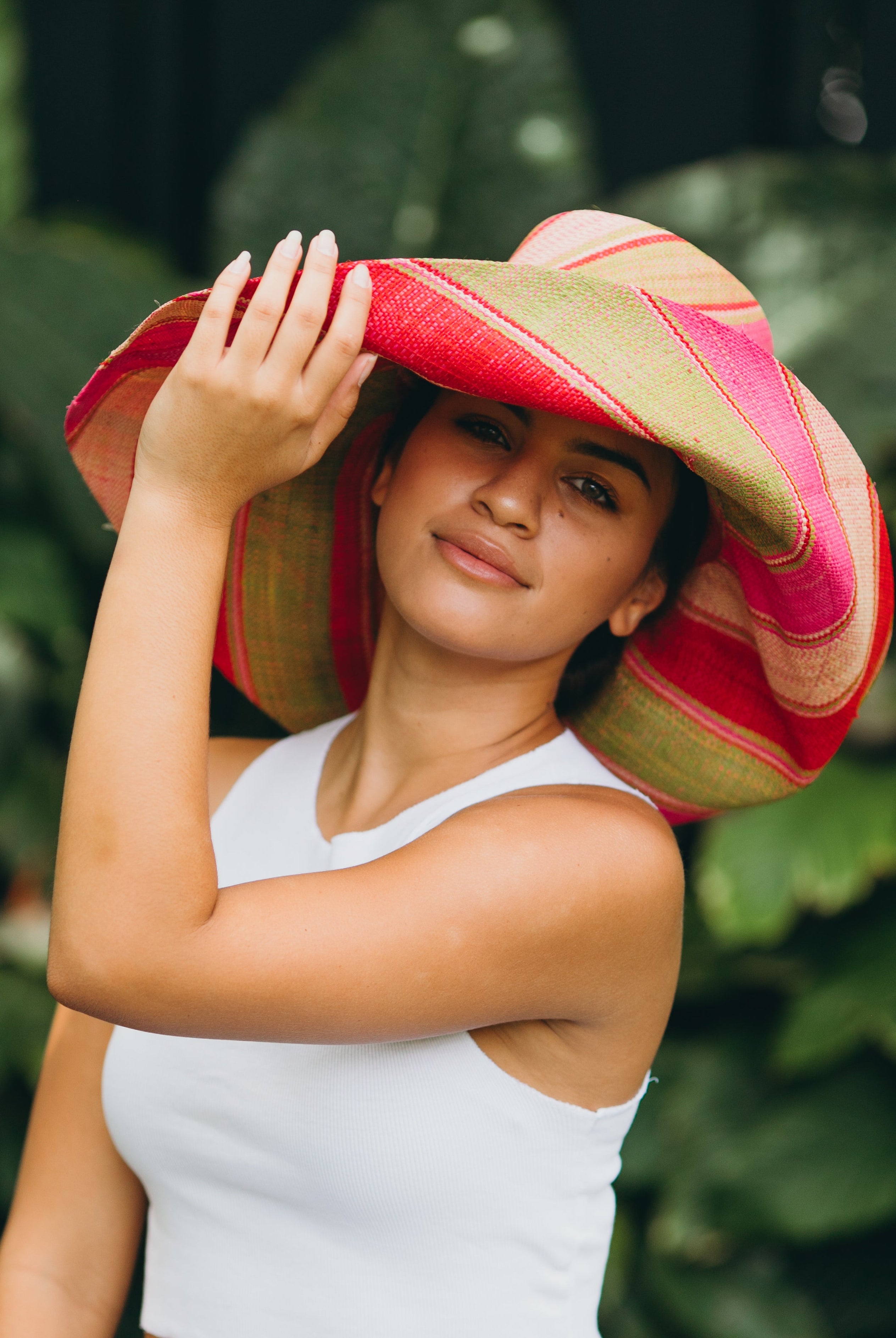 Model wearing Monica 7" Wide Brim Pink & Midori Swirl Multicolor Stripes Packable Straw Sun Hat Handmade loomed raffia in multi width bands of fuchsia pink, red, light pink, midori lime/green, and natural straw color create a swirl pattern - Shebobo