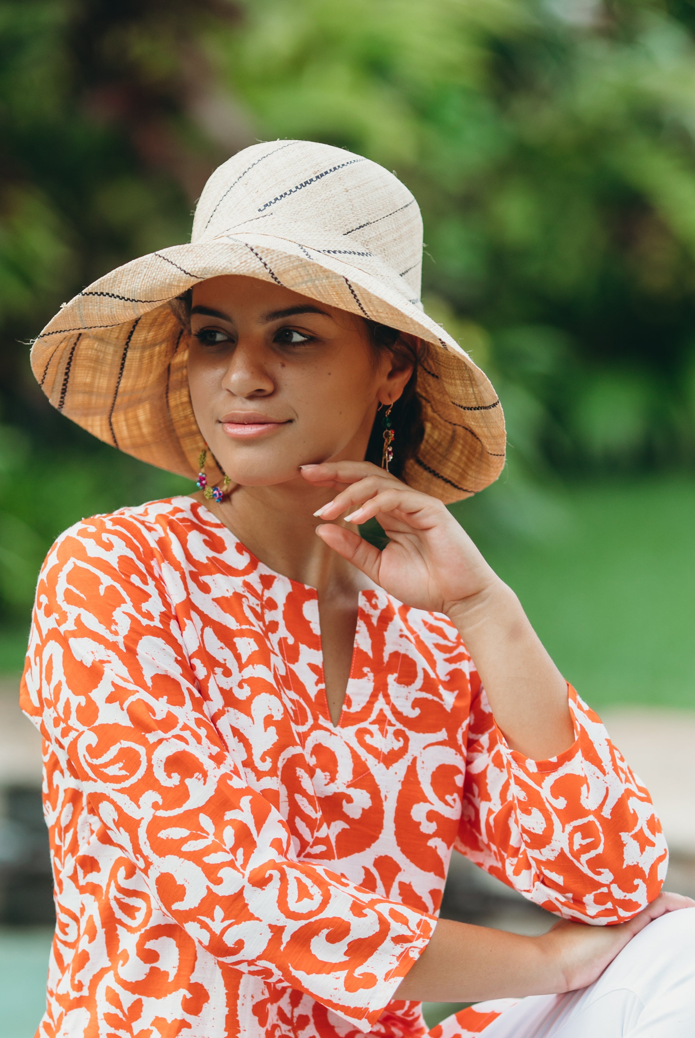 Model wearing Monica 5" wide brim natural and black pinstripes packable raffia straw hat handmade loomed raffia in wide bands of natural straw color with black narrow bands create a stripe swirl pattern - Shebobo