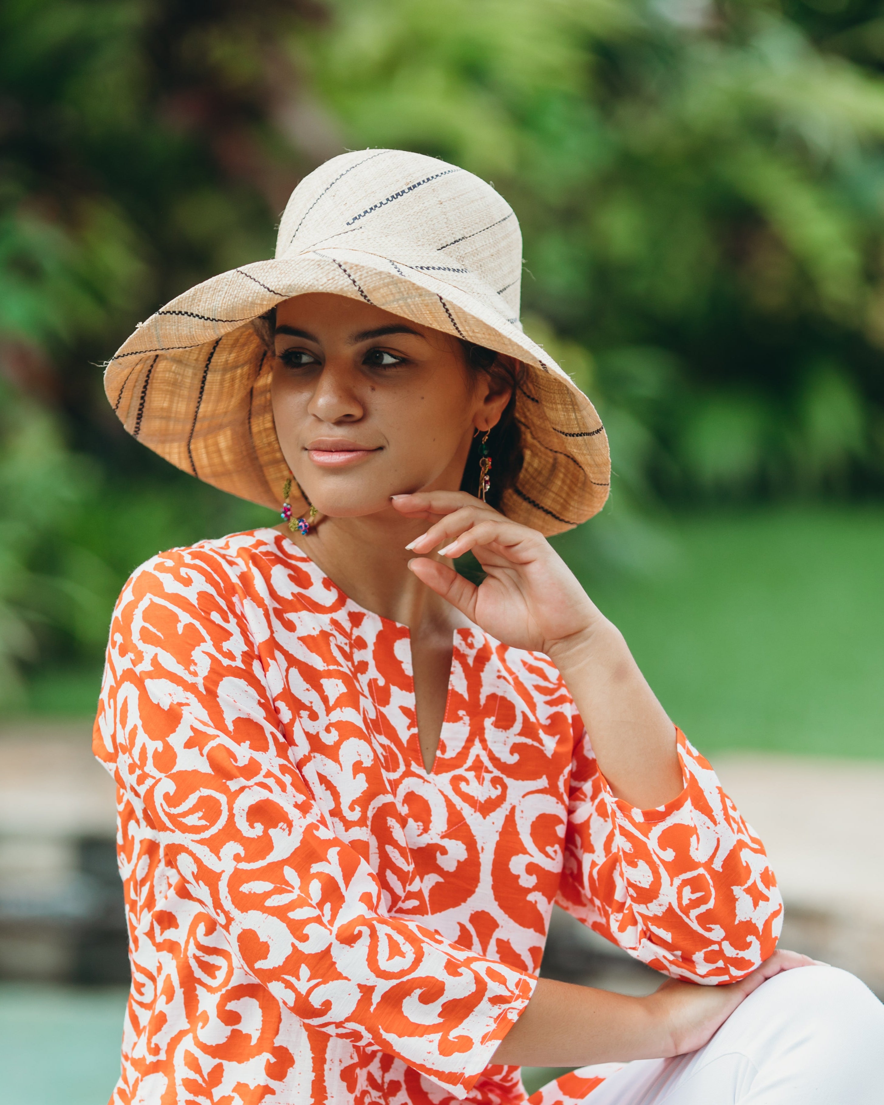 Model wearing Monica 5" wide brim natural and black pinstripes packable raffia straw hat handmade loomed raffia in wide bands of natural straw color with black narrow bands create a stripe swirl pattern - Shebobo