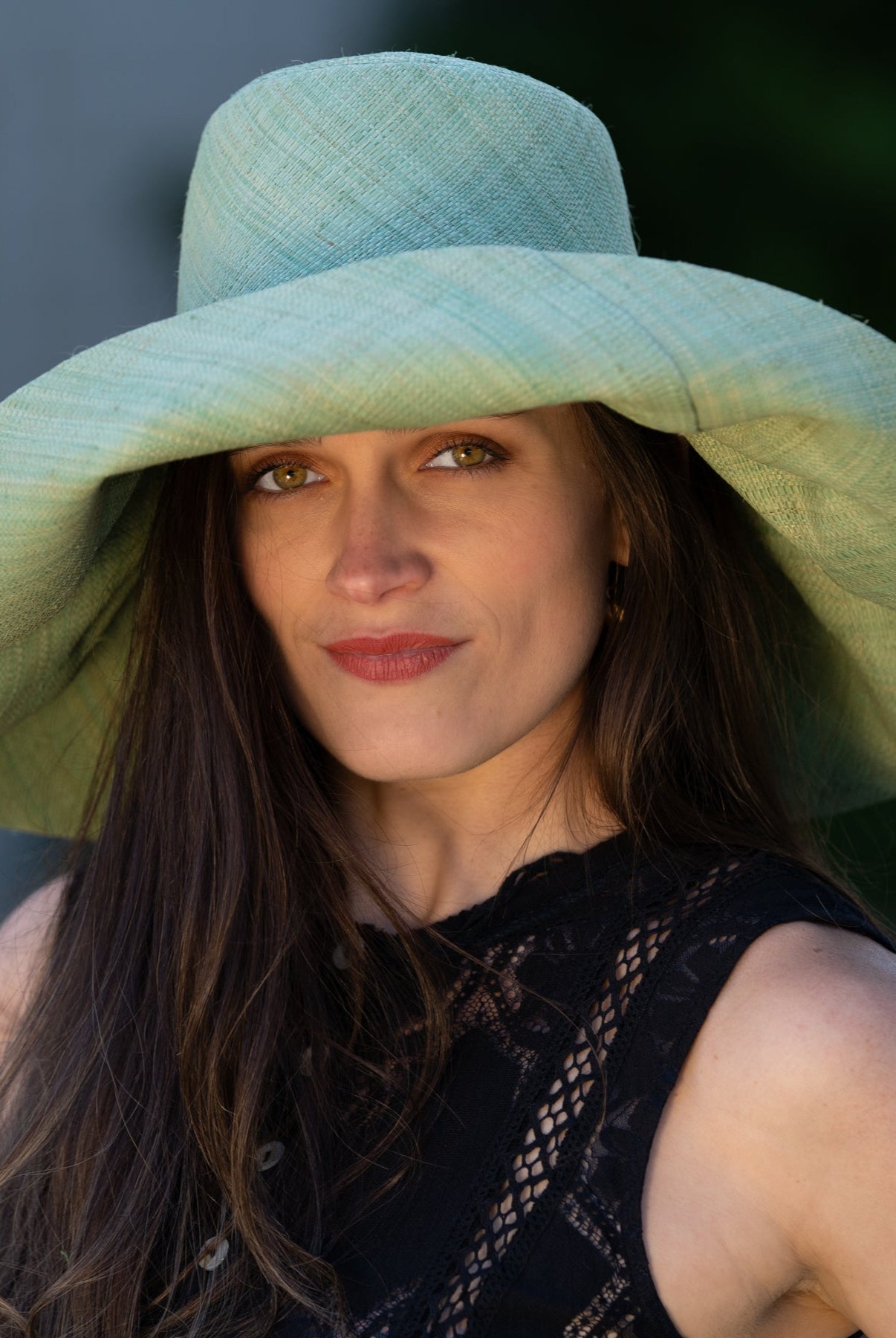 Model wearing Monica 7" Wide Brim Seafoam Packable Straw Sun Hat handmade loomed raffia in a solid hue of seafoam light/green/blue lightweight malleable flexible sun protection hat - Shebobo