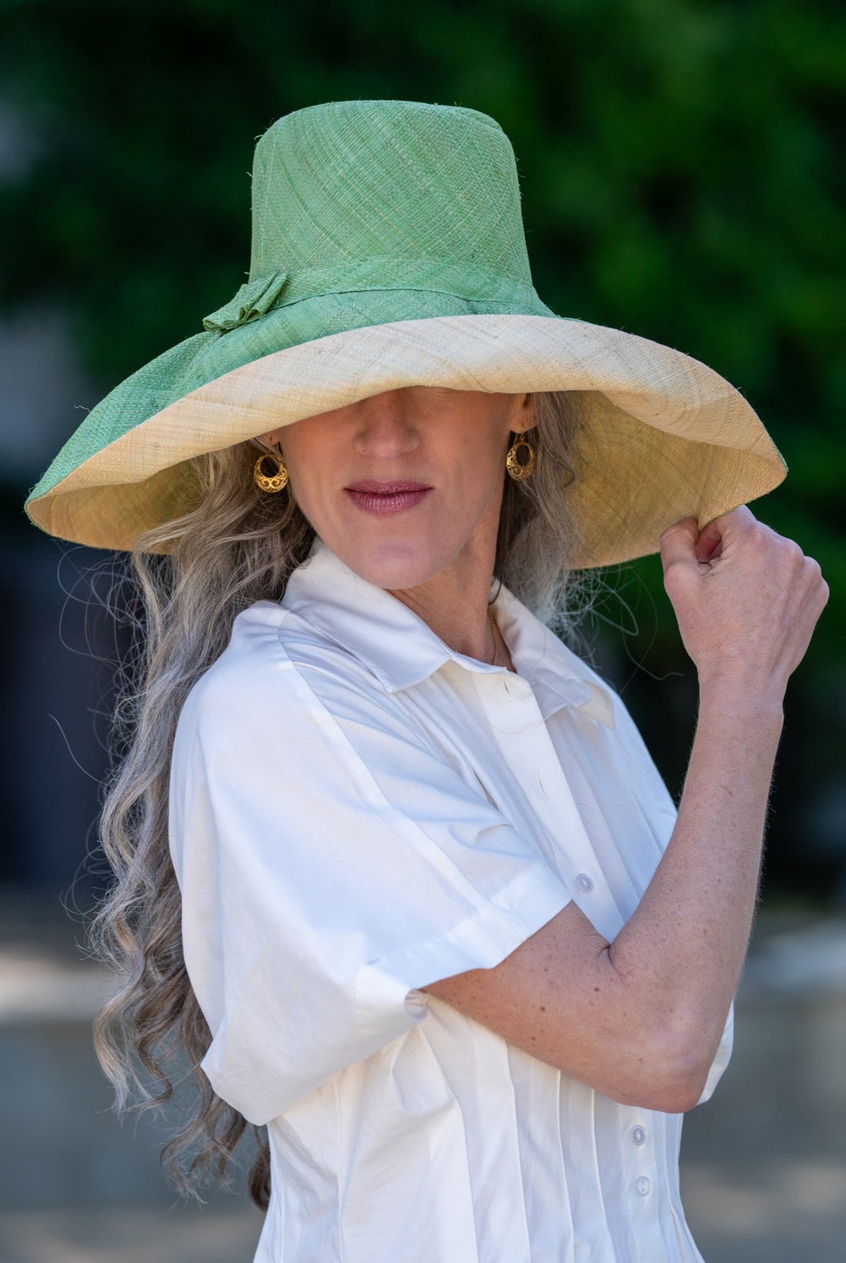 Model wearing Monica 7" wide brim handmade seafoam light/bluegreen top half and natural straw color bottom half two tone loomed raffia sun protection packable lightweight straw hat - Shebobo