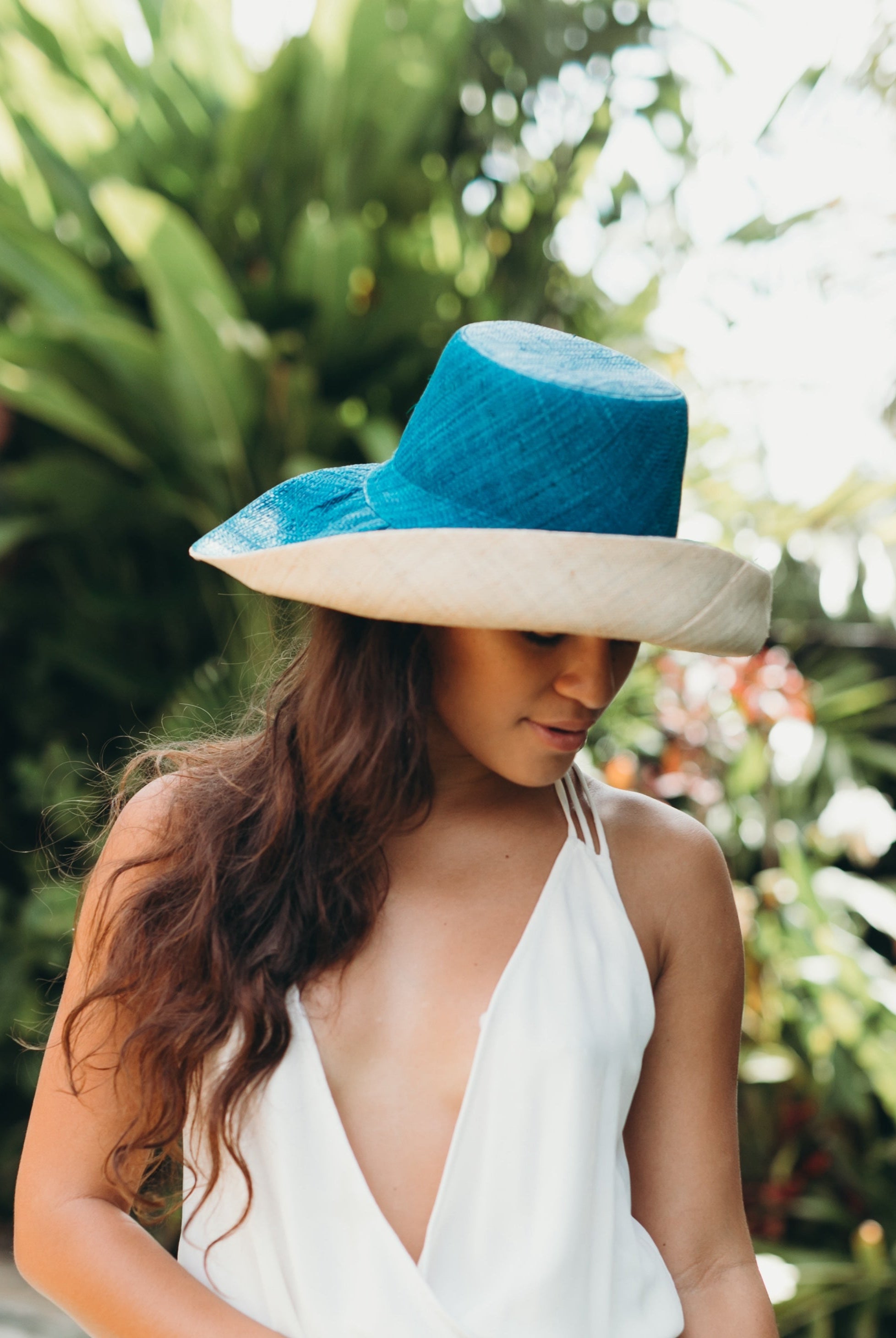 Model wearing Monica 5" wide brim handmade teal dark/blue/green top half and natural straw color bottom half two tone loomed raffia sun protection packable lightweight straw hat - Shebobo