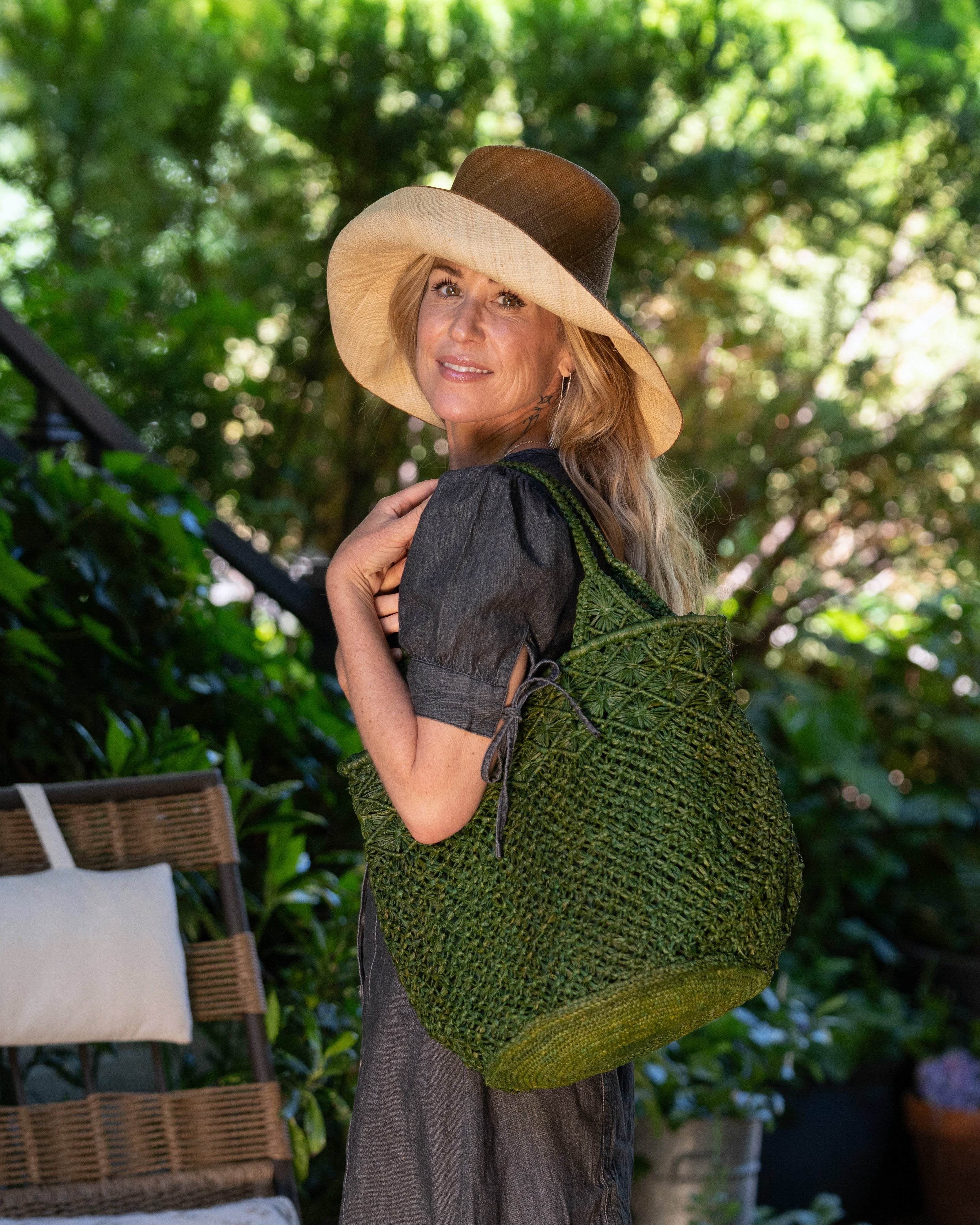 Model wearing Monica 5" Brim Two Tone Cinnamon Straw Hat handmade loomed raffia color block pattern of the top half cinnamon/tobacco/brown and the bottom half natural straw color - Shebobo (with Luca Macrame Diamond and Crochet Straw Handbag)
